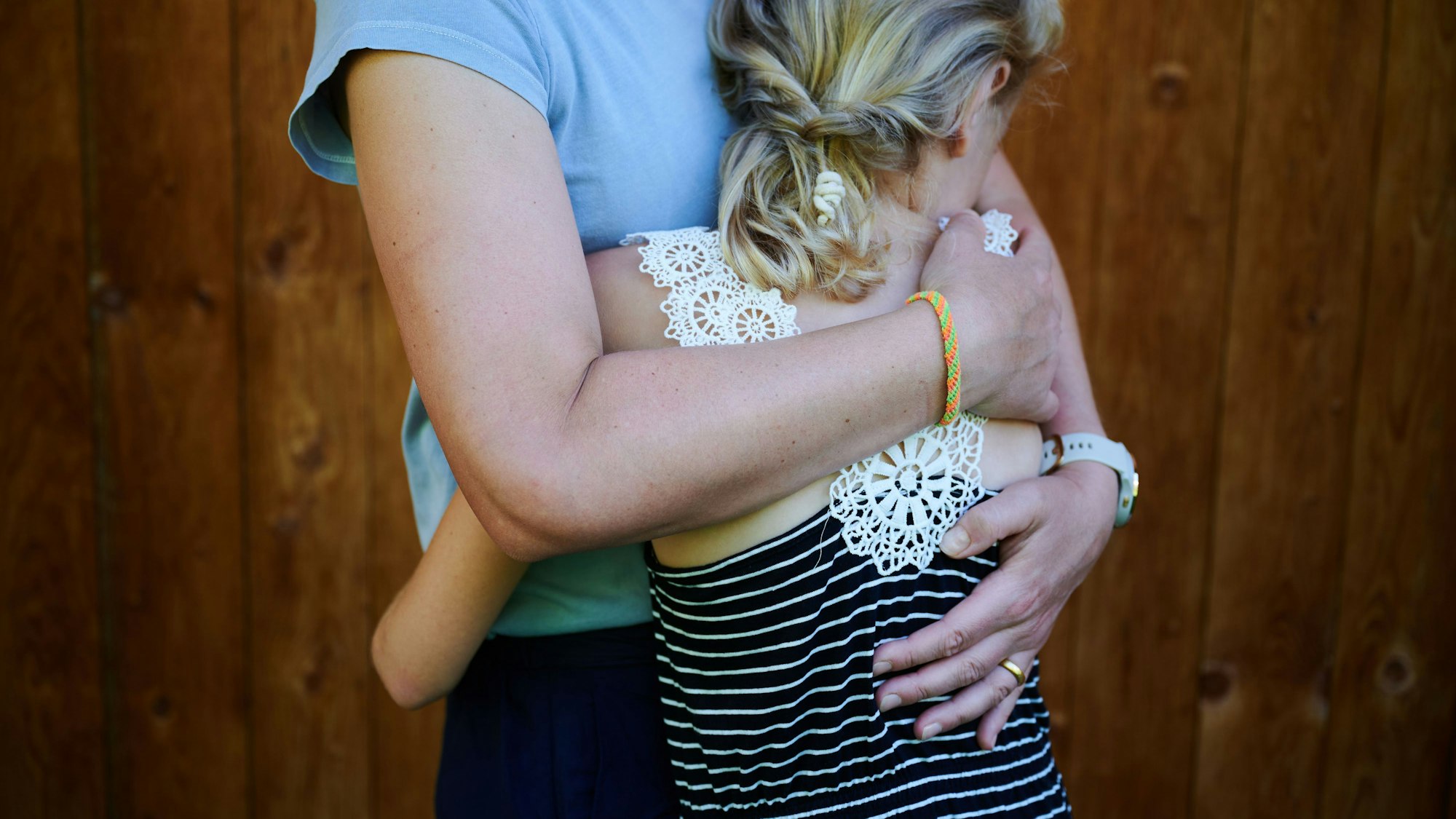 Ein Mädchen wird von seiner Mutter in den Arm genommen und getröstet.