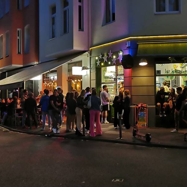 Menschen stehen vor dem Kiosk am Brüsseler Platz.