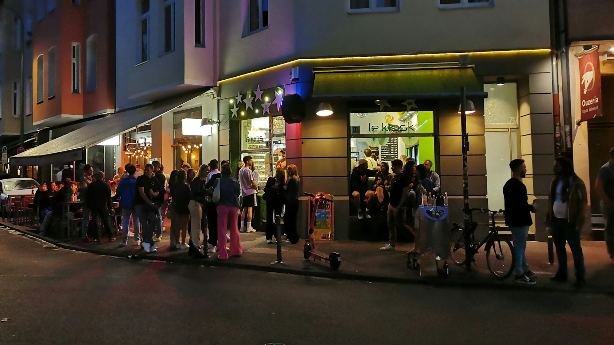 Menschen stehen vor dem Kiosk am Brüsseler Platz.