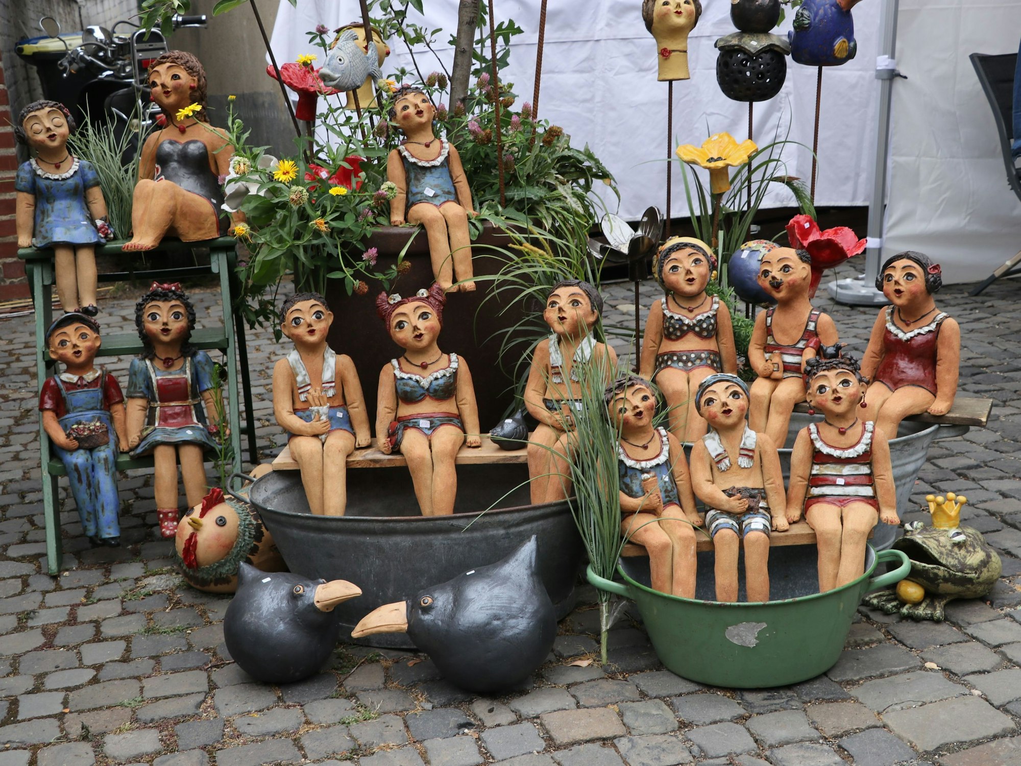 Auf dem Foto sind Keramikfiguren in Badebekleidung zu sehen.