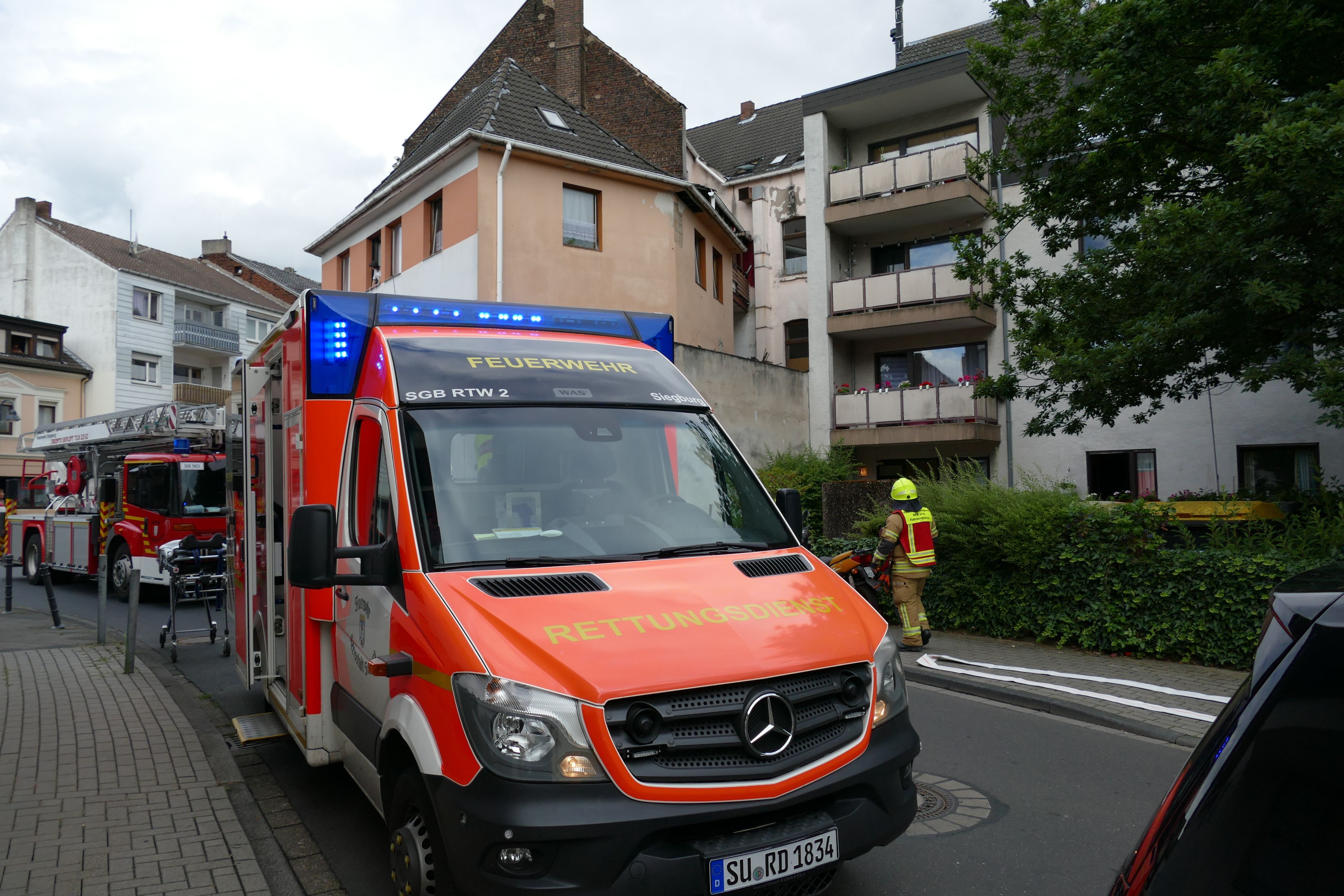 Ein Rettungswagen steht vor einem Mehrfamilienhaus.