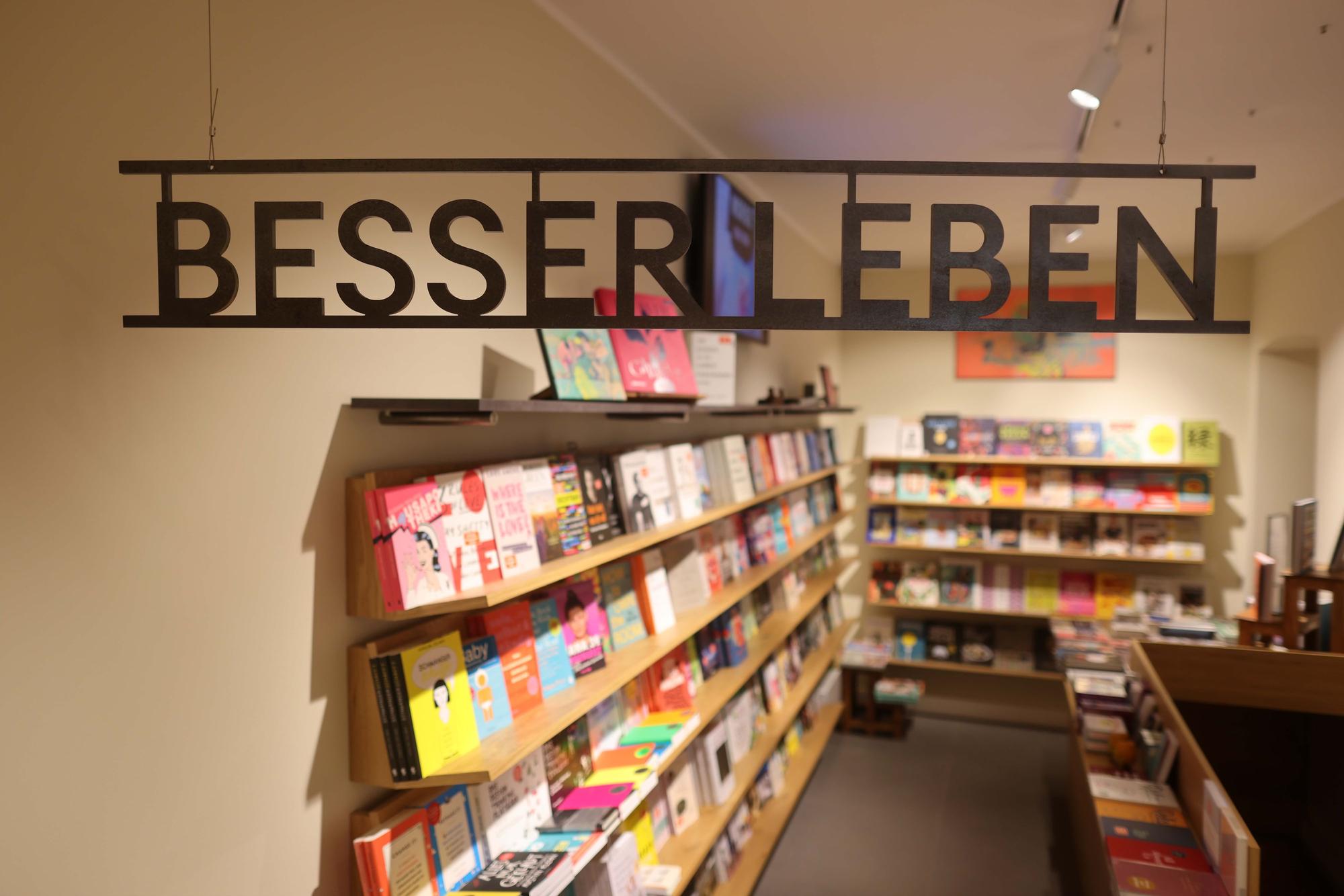 Bücher stehen auf Bücherregale und ein Schriftzug zeigt „Besser leben“.