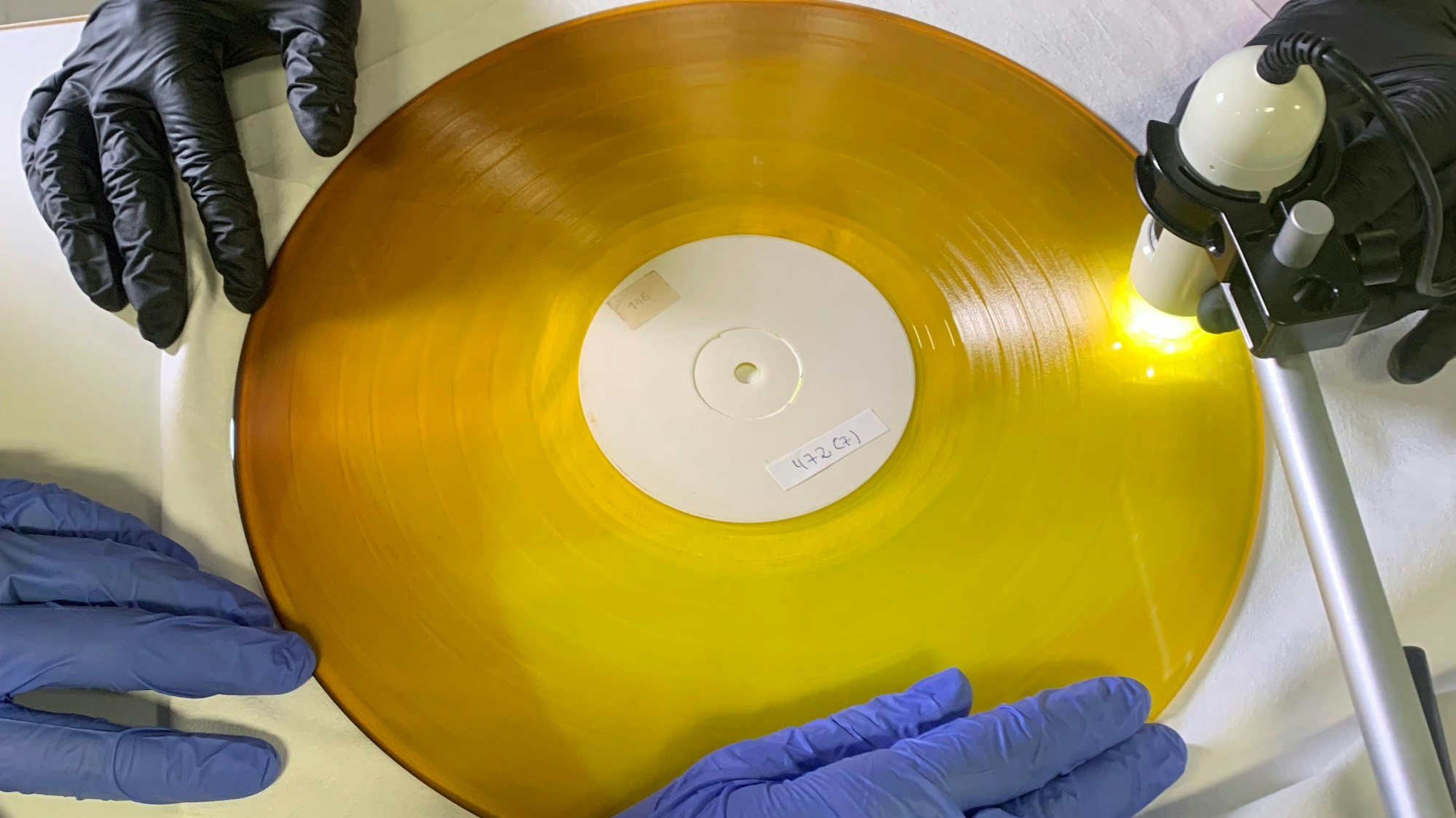 Studierende der Hochschule Köln des Masterstudienganges Restaurierungs- und Konservierungswissenschaften restaurieren einen Rohling einer Schallplatte.