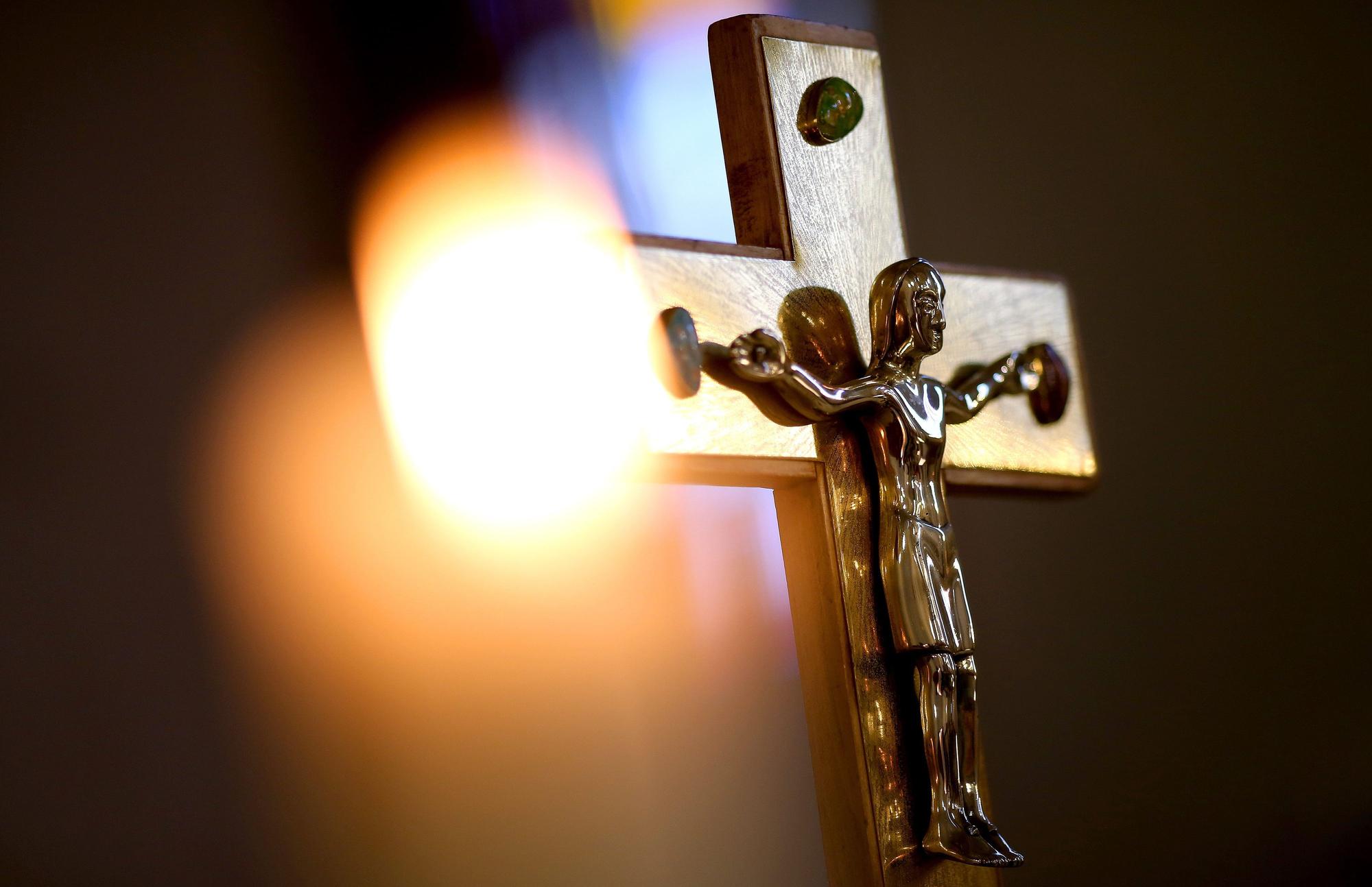 Jesuskreuz mit brennender Kerze.