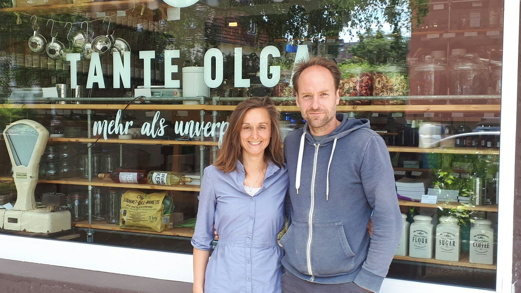 Ein junges Paar steht vor dem Schaufenster eines Ladenlokals.
