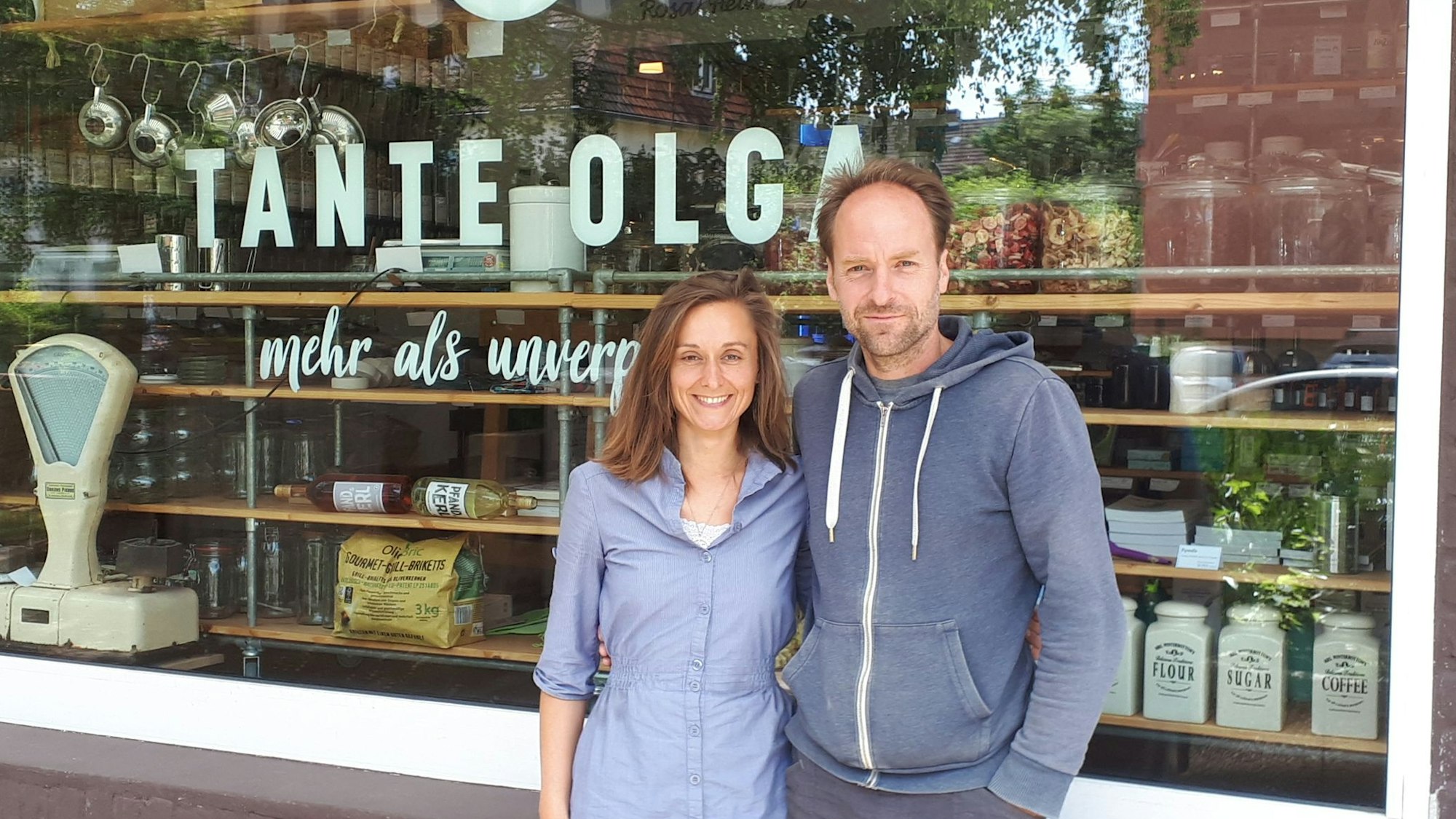 Ein junges Paar steht vor dem Schaufenster eines Ladenlokals.