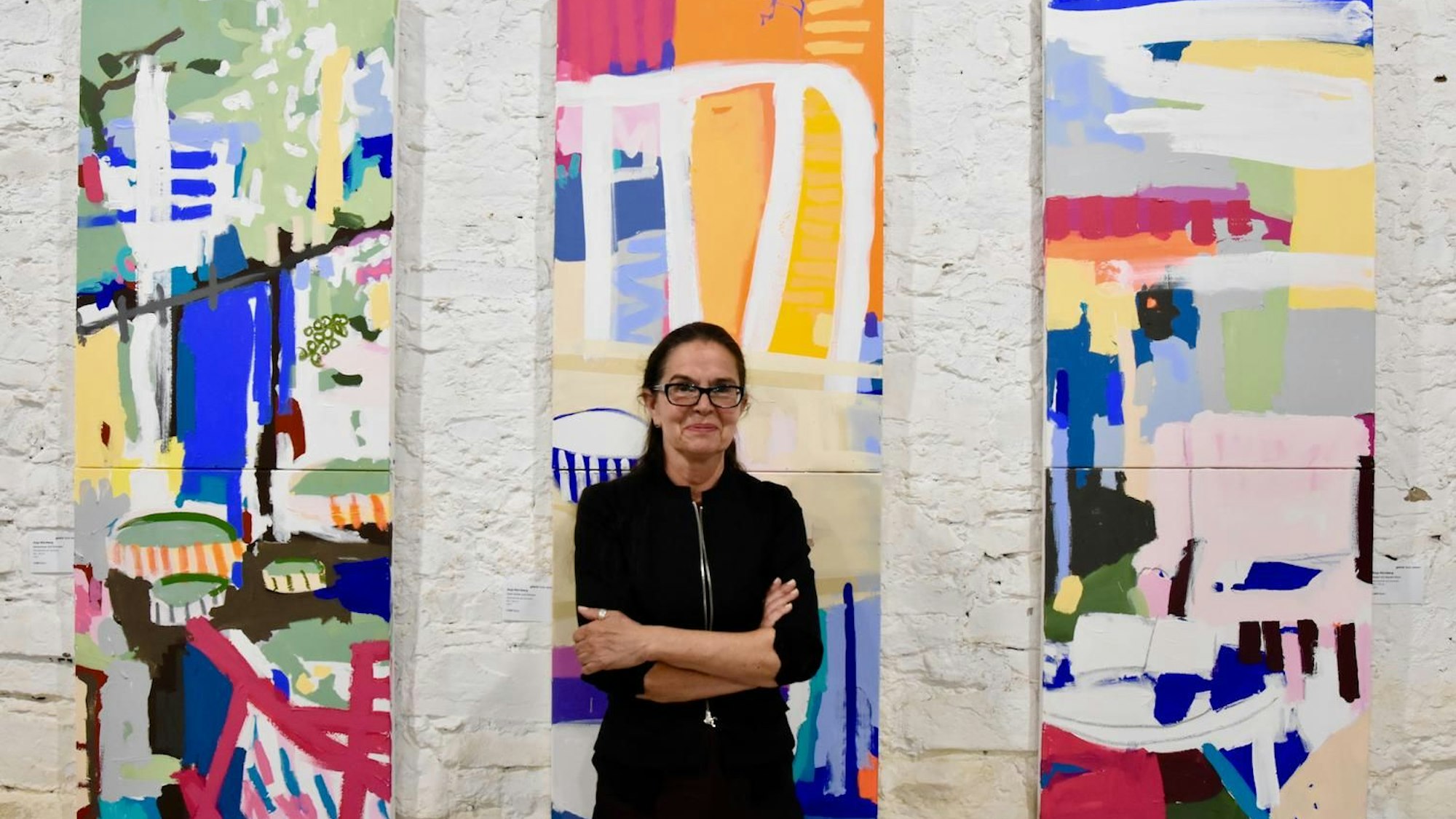 Luzia Sassen steht vor mehreren Kunstwerken.