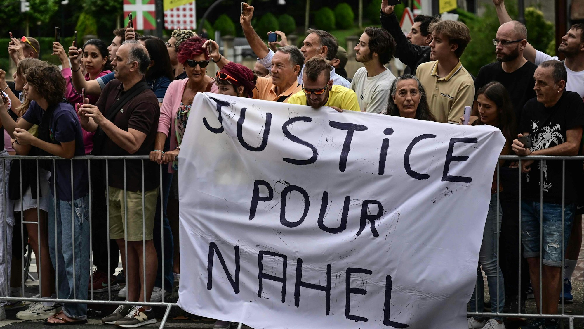 "Justice for Nahel“ steht auf einem Banner am Streckenrand der Tour de France