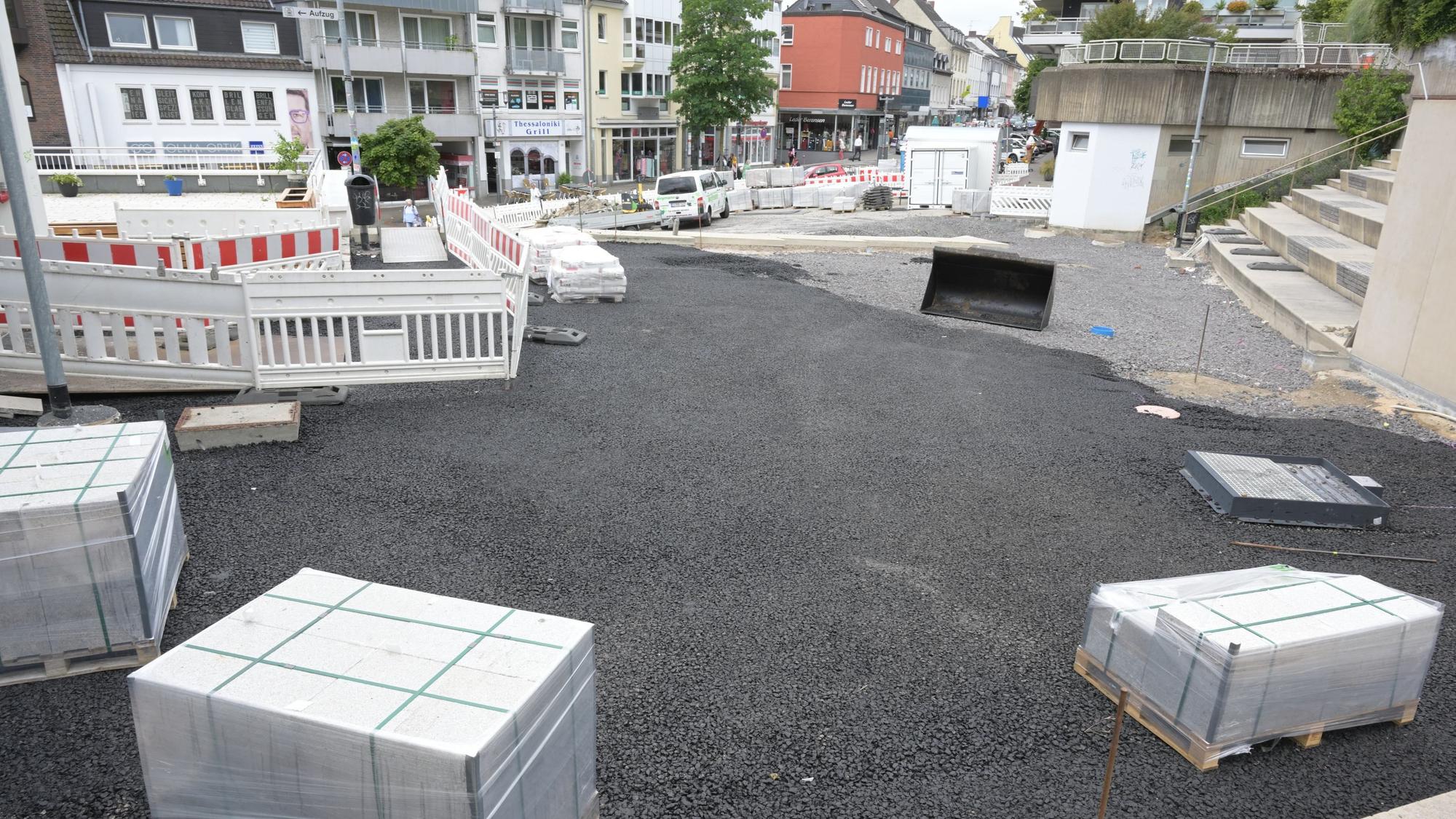 Blick von der Schlosstreppe auf den Vorplatz: Die Granitstein-Paletten stehen bereit, der Untergrund ist mit einer schwarzen Asphaltschicht vorbereitet.