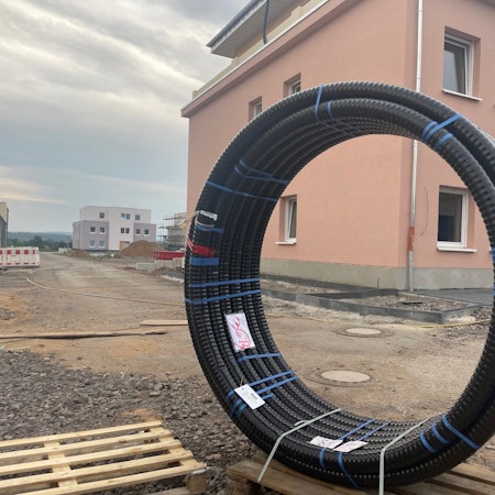 Das Foto zeigt eine Baustelle mit einem fast fertig gebauten Haus.