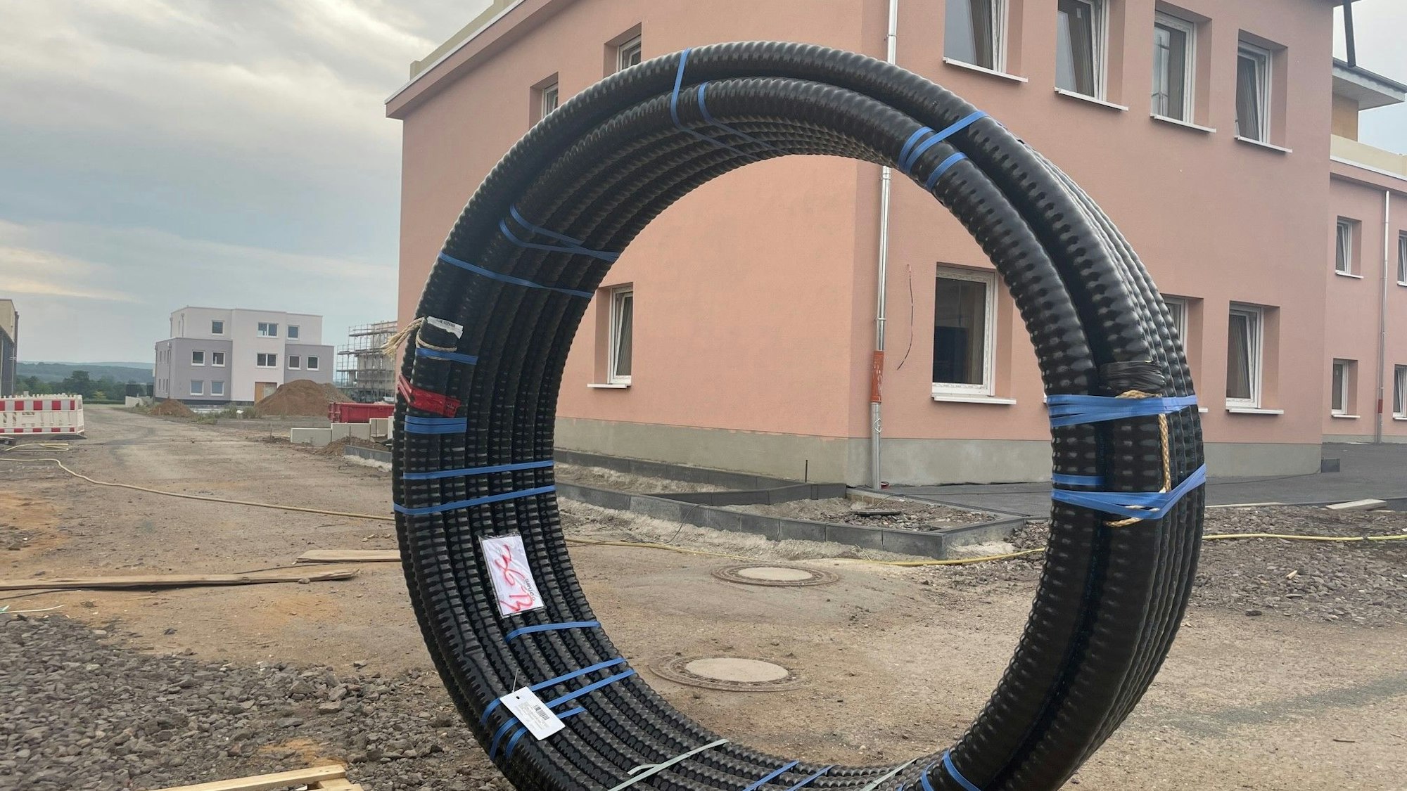 Das Foto zeigt eine Baustelle mit einem fast fertig gebauten Haus.