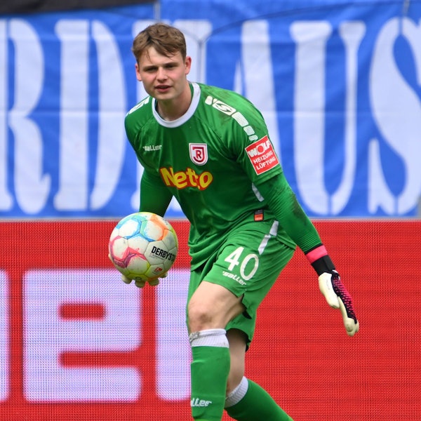 Jonas Urbig hält einen Ball in der Hand.