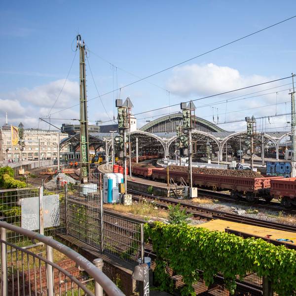 In der Einfahrt zum Kölner Hauptbahnhof stehen mit Schotter beladene Güterwagen.