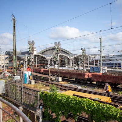 In der Einfahrt zum Kölner Hauptbahnhof stehen mit Schotter beladene Güterwagen.