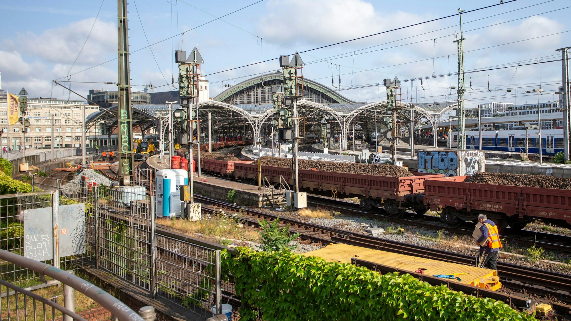 In der Einfahrt zum Kölner Hauptbahnhof stehen mit Schotter beladene Güterwagen.