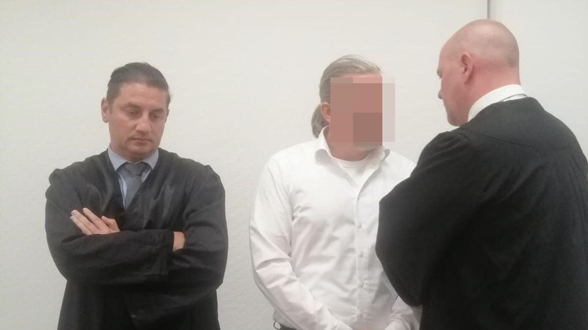 Das Bild zeigt den Hürther mit seinen beiden Anwälten.