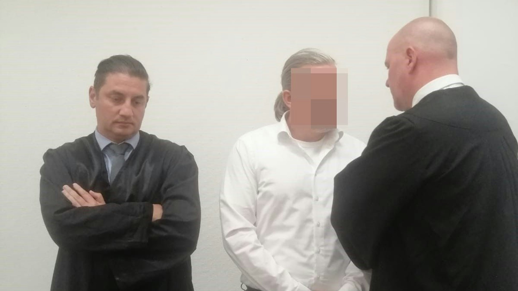 Das Bild zeigt den Hürther mit seinen beiden Anwälten.