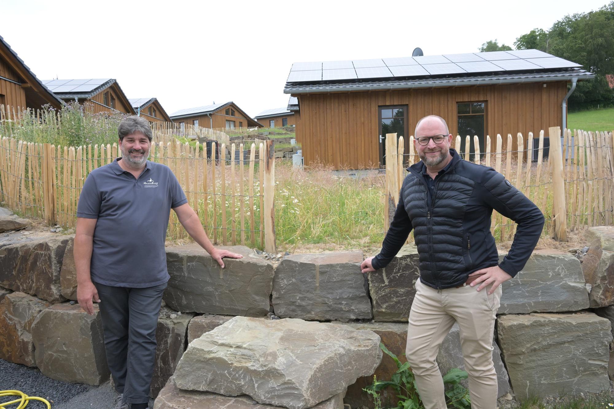 Harald Daunheimer und Matthias Korte stehen vor einer halbhohen Mauer aus großen Begrenzungssteinen.