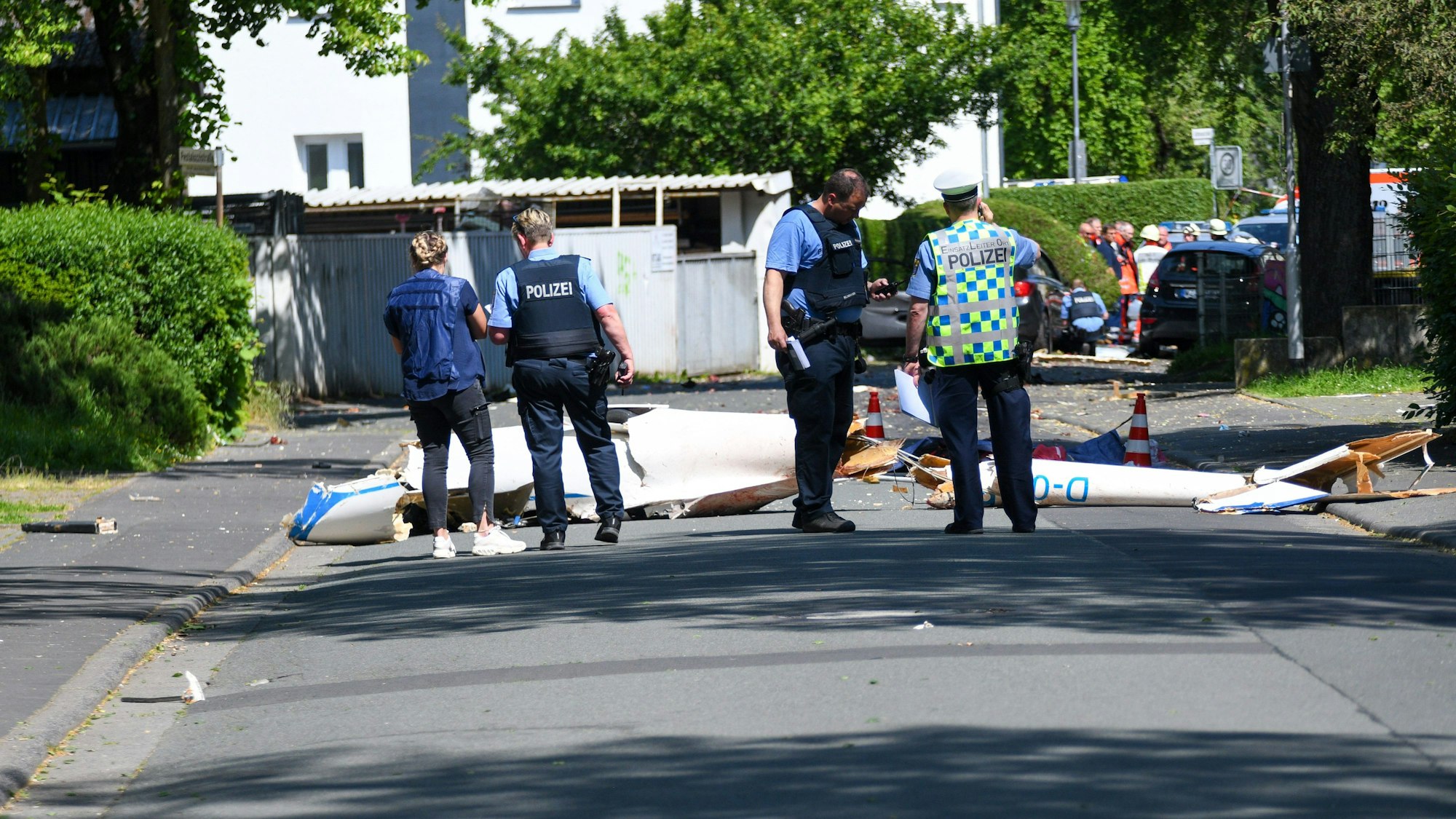Trümmer liegen auf der Straße nach dem Absturz eines Leichtflugzeugs im Stadtgebiet von Wetzlar.