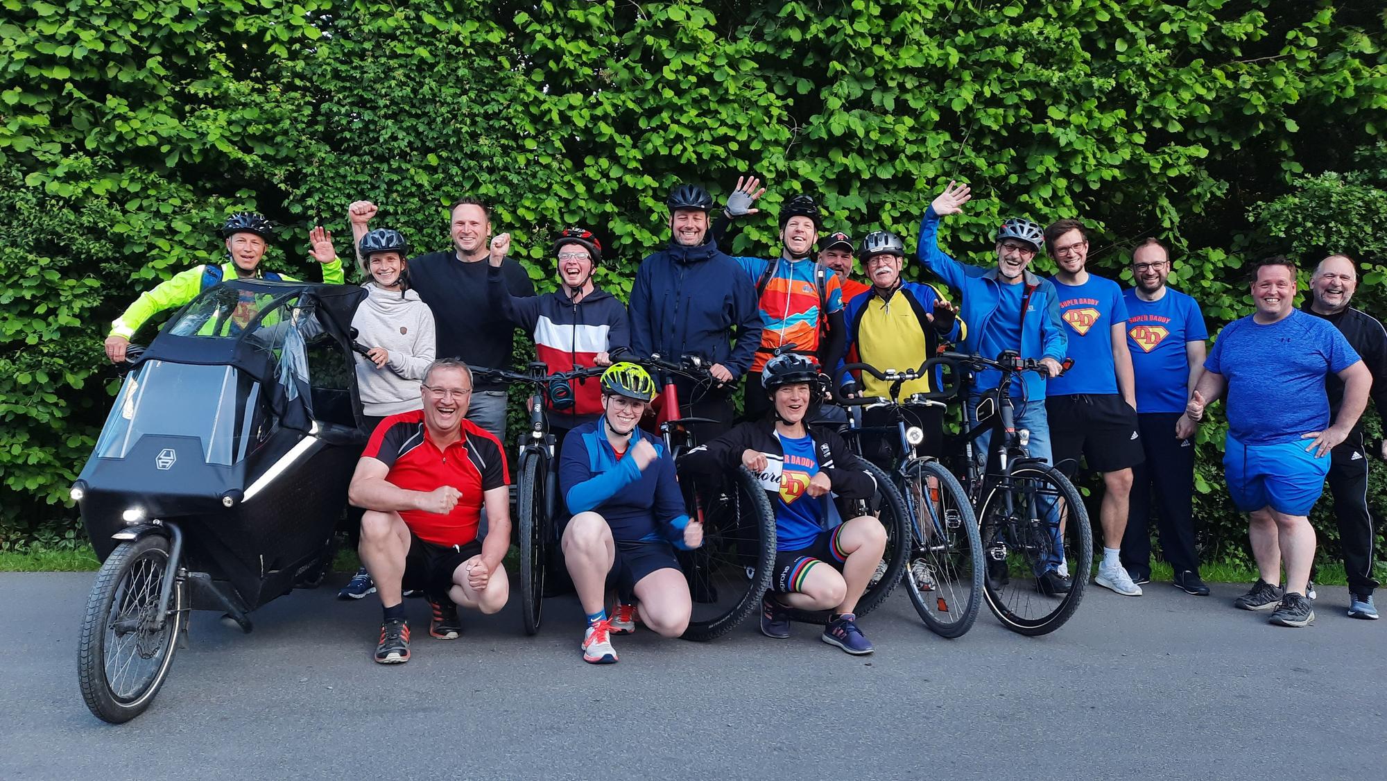 Die Mitglieder der Tanzgruppe Dancing Daddys des SV Frielingsdorf haben sich mit ihren Fahrrädern und in Sportkleidung zum Gruppenbild aufgestellt.