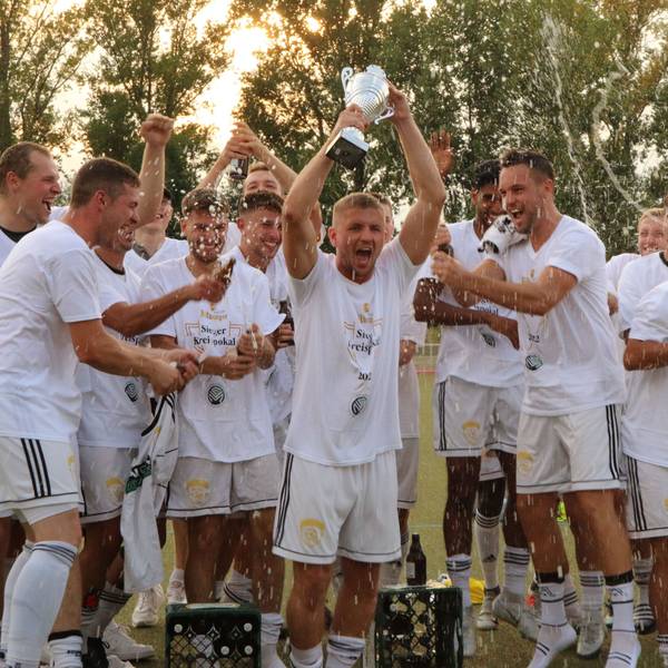 Die Spieler des SC Germania Erftstadt-Lechenich jubeln nach dem Sieg im Endspiel und recken den Pokal in die Höhe.