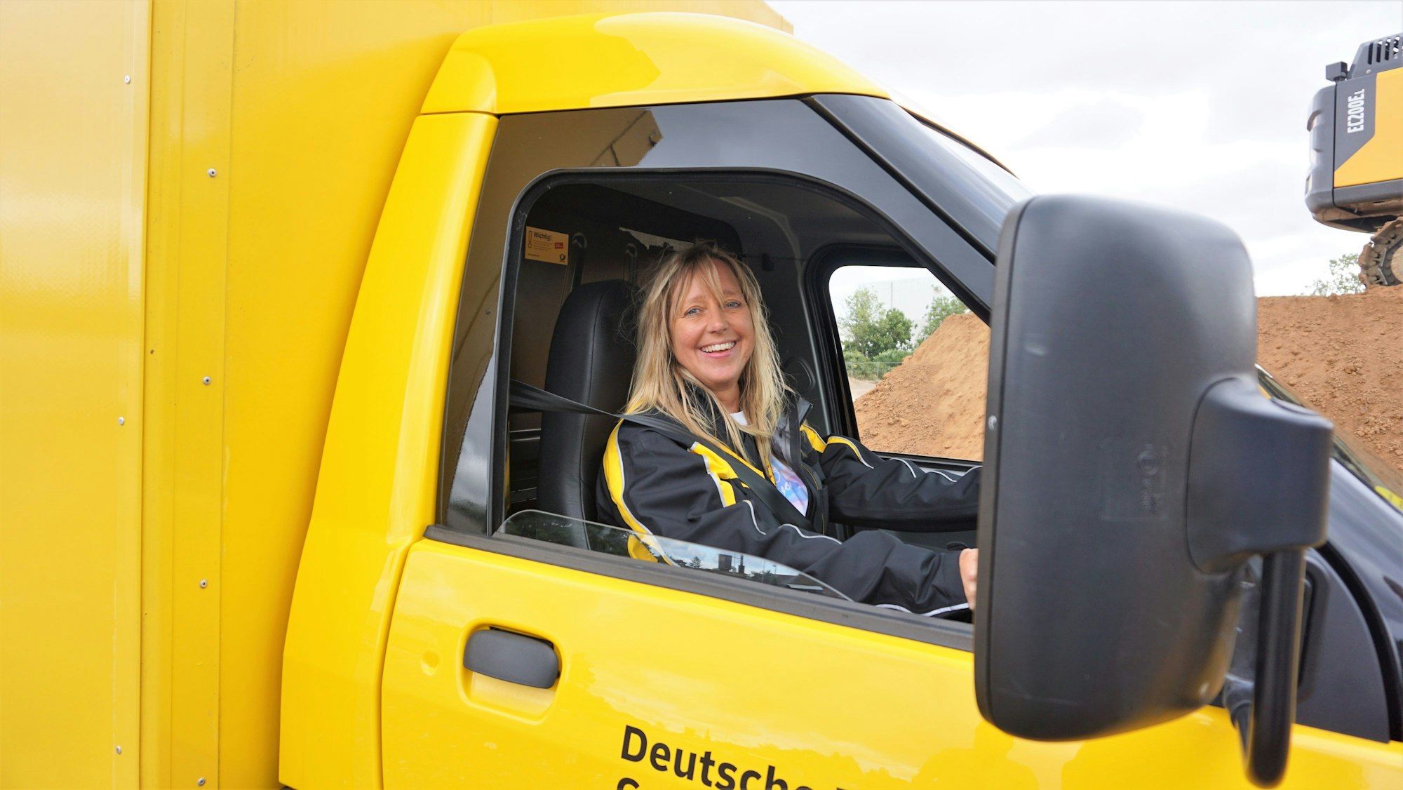 Sabine Kersen, sitzt am Lenkrad eines E-mobils der Deutschen Post.