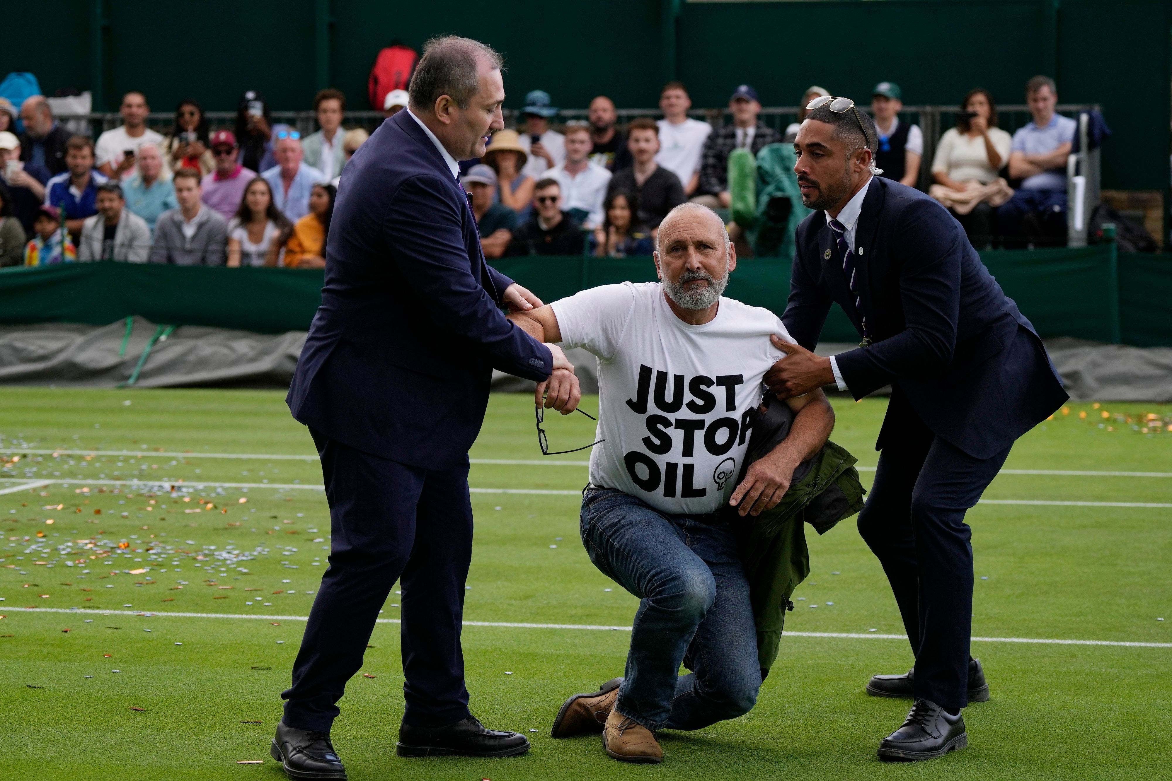 Ein Just Stop Oil-Protestler wird am dritten Tag der Wimbledon-Tennismeisterschaften von Court 18 entfernt.