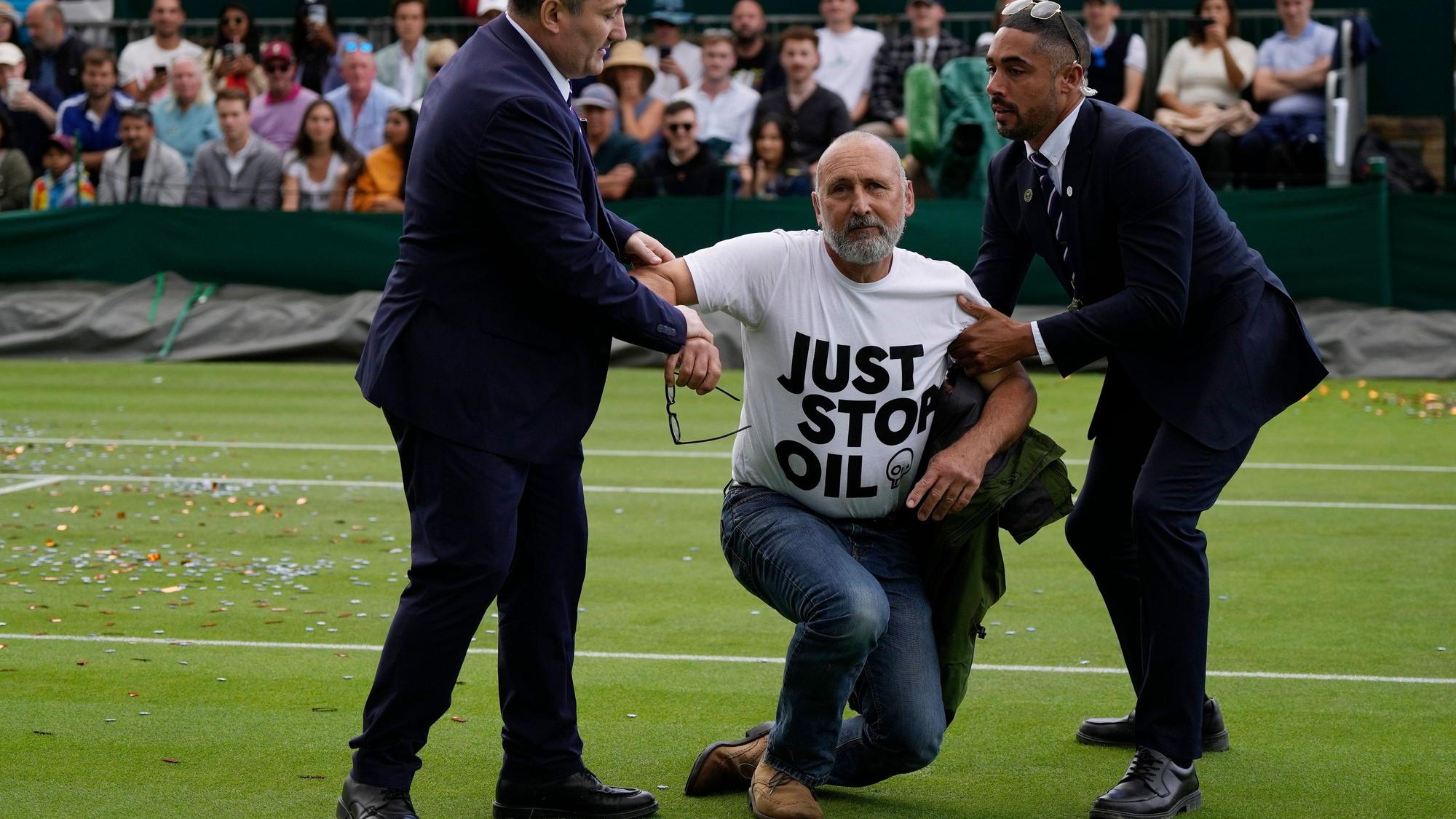 Ein Just Stop Oil-Protestler wird am dritten Tag der Wimbledon-Tennismeisterschaften von Court 18 entfernt.