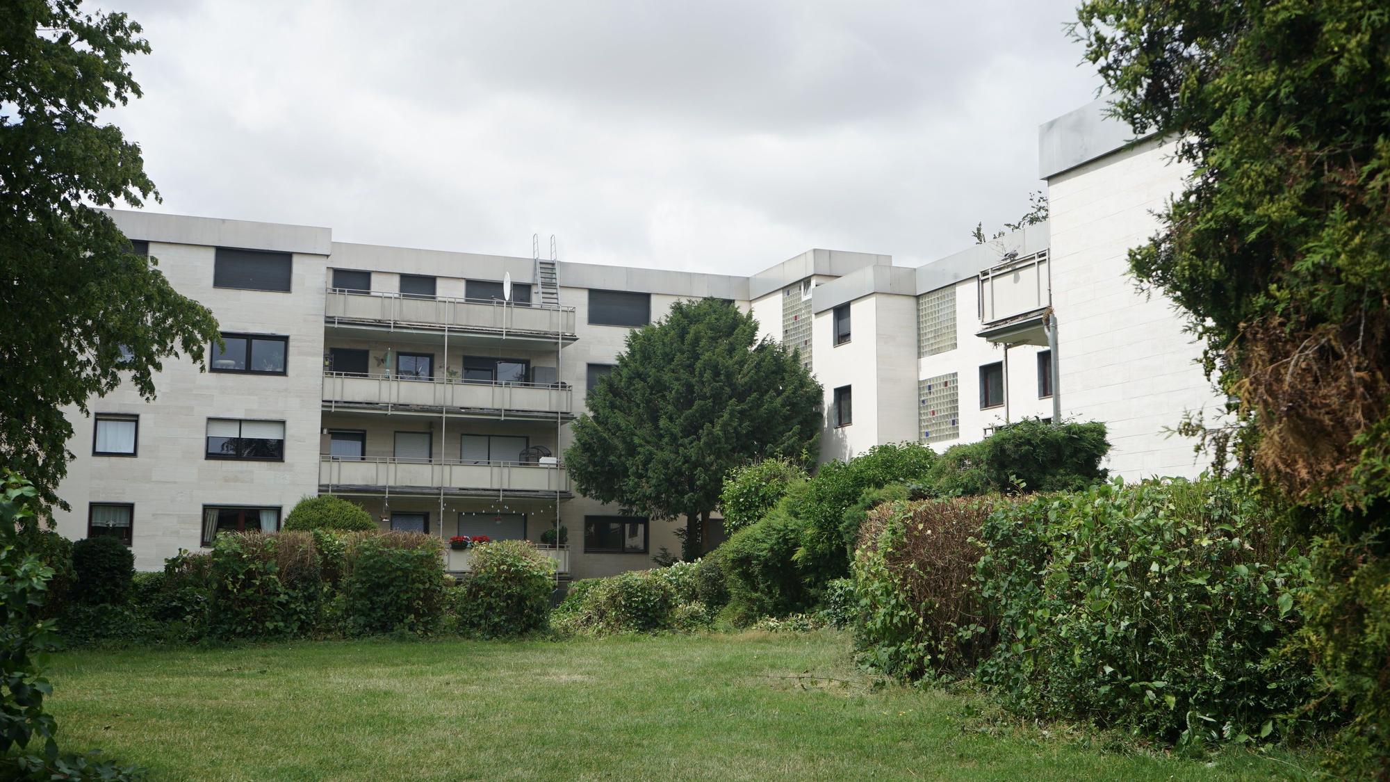 Das Bild zeigt den Aher Wohnpark, einen grau-weißen Betonbau.