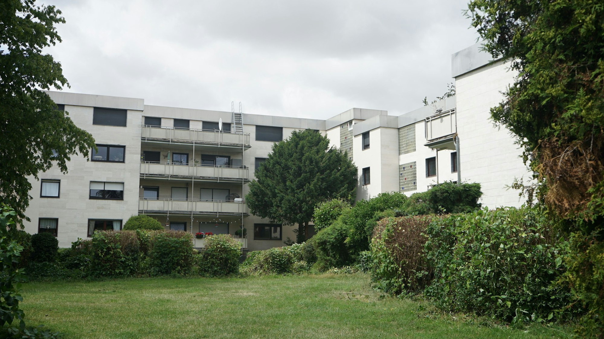 Das Bild zeigt den Aher Wohnpark, einen grau-weißen Betonbau.