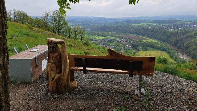 Bank an einem Aussichtspunkt, links daneben eine große Holzkiste