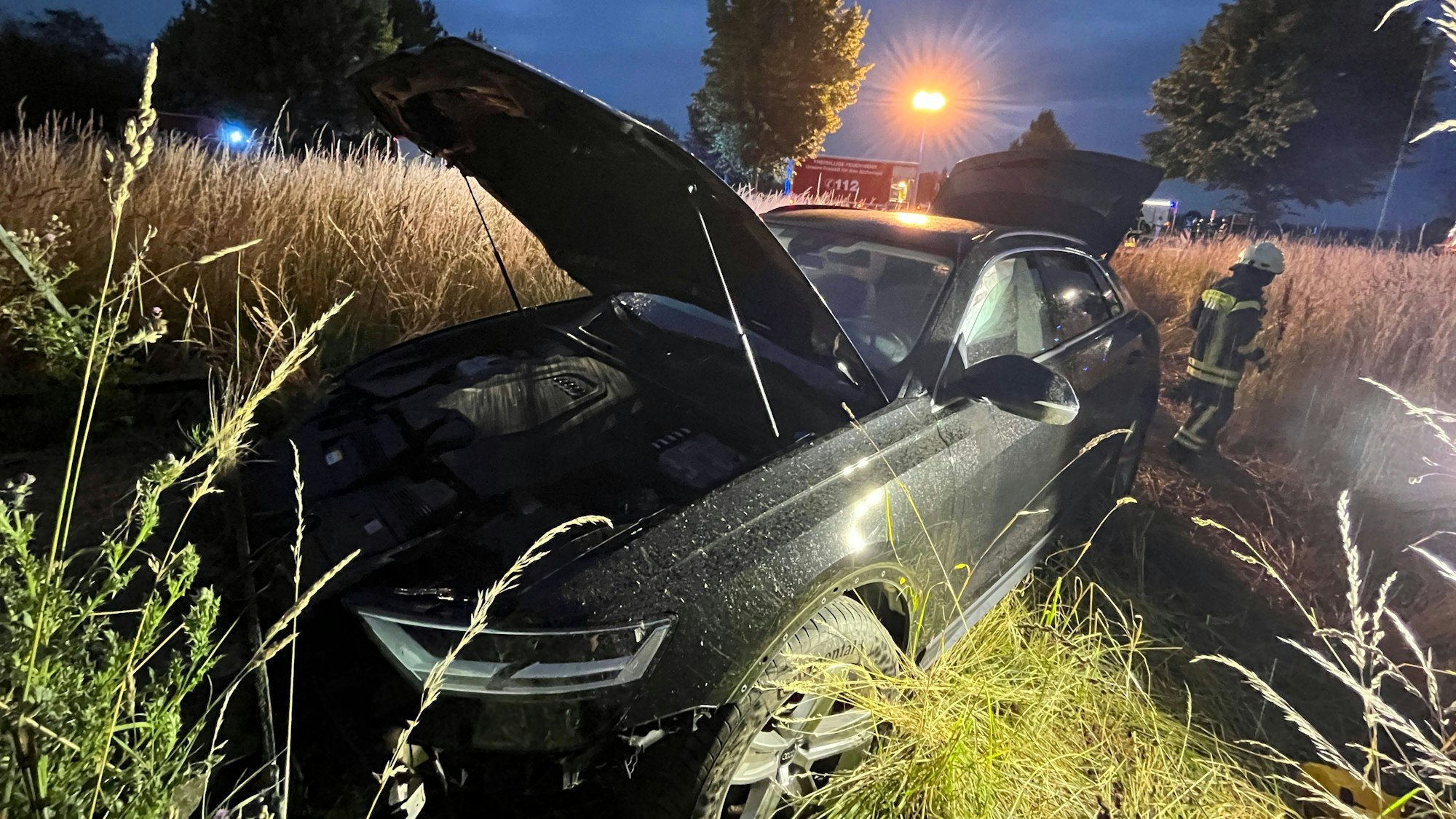 Ein Auto mit offener Motorhaube im Feld.