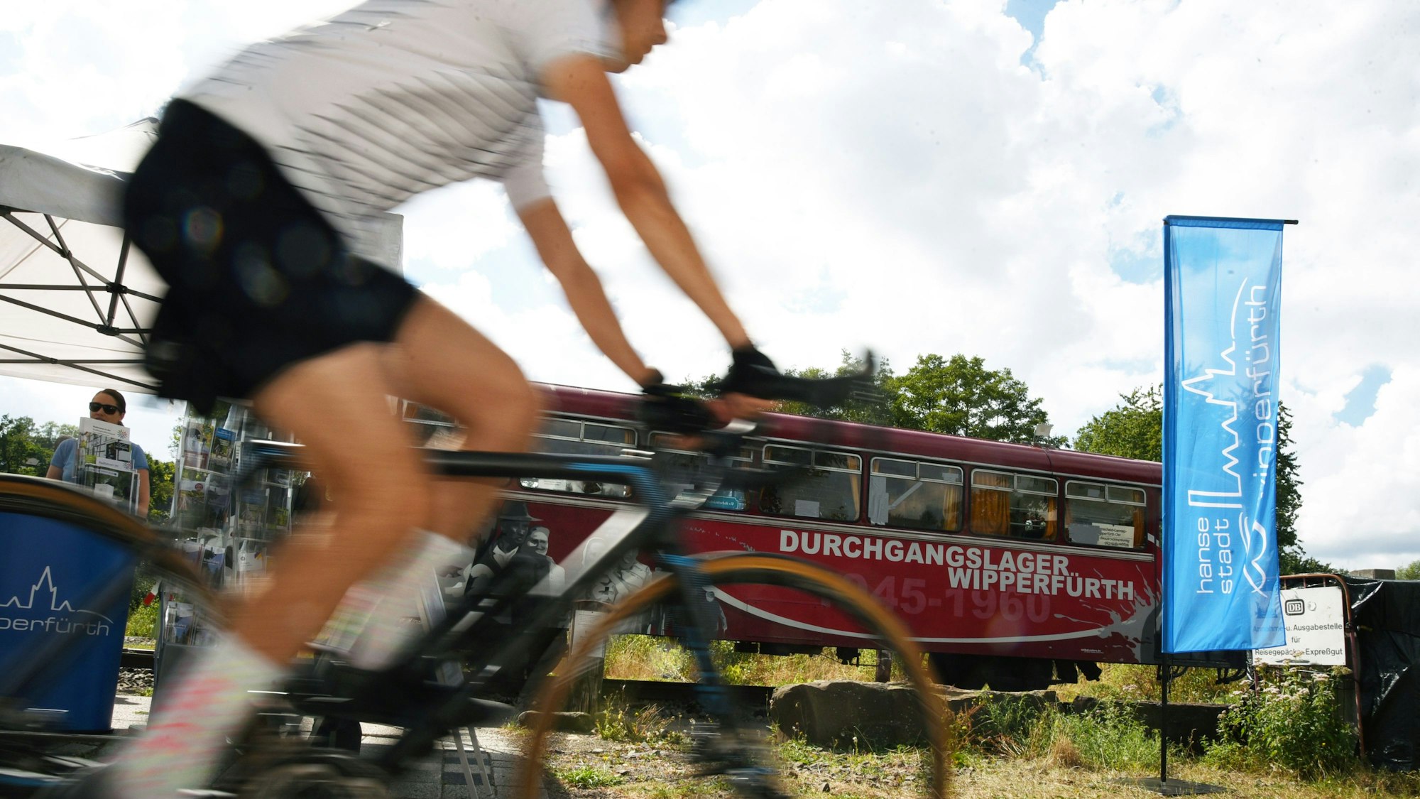 Radfahrer fährt auf dem Rad- und Gehweg auf dem früheren Bahndamm in Wipperfürth am Ausstellungsort Bahnlandschaften vorbei.