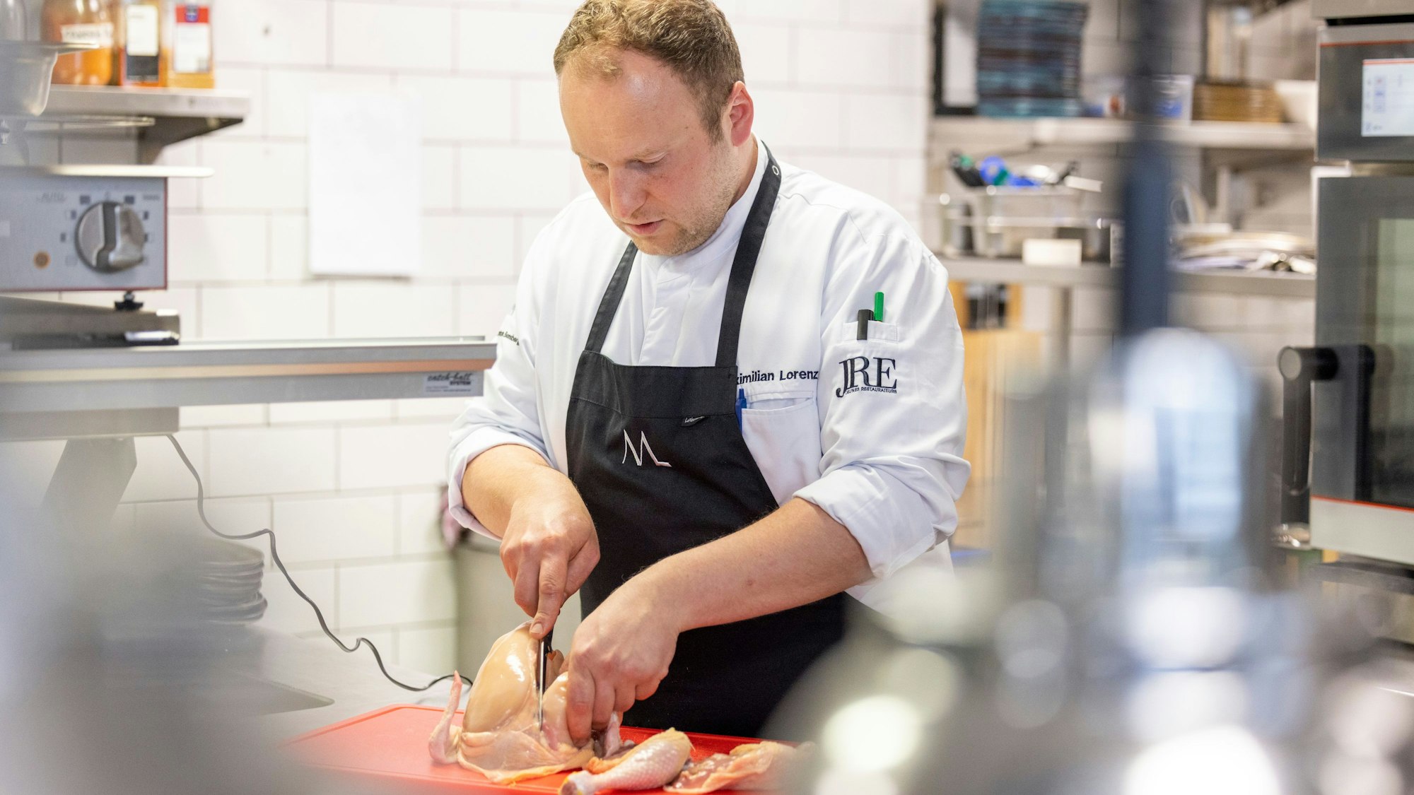 Der Kölner Sternekoch Maximilian Lorenz zerlegt in der Küche des „Maximilian Lorenz“ ein Huhn.
