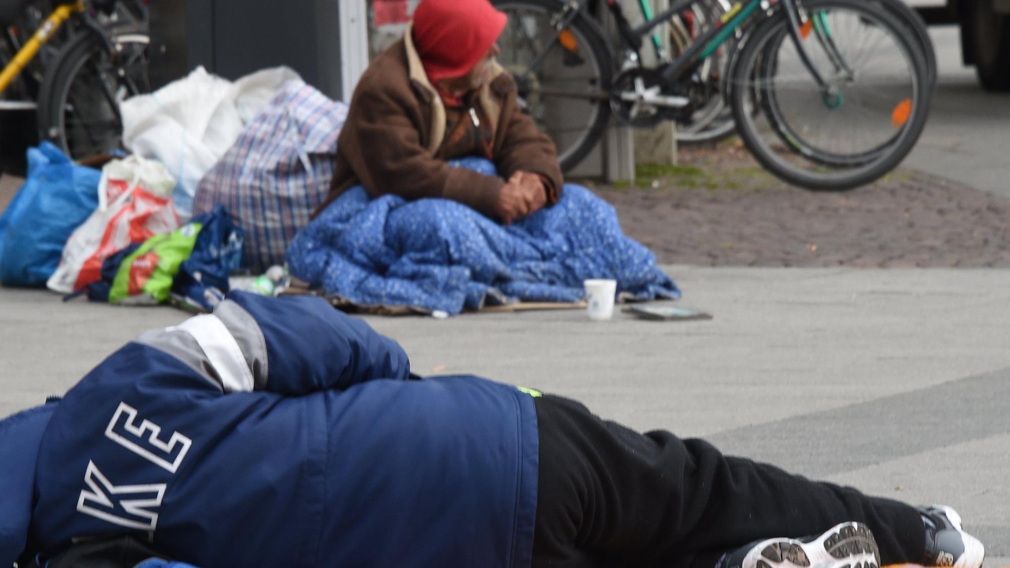 Obdachlose Männer schlafen in einer geschützten Stelle auf der Straße.