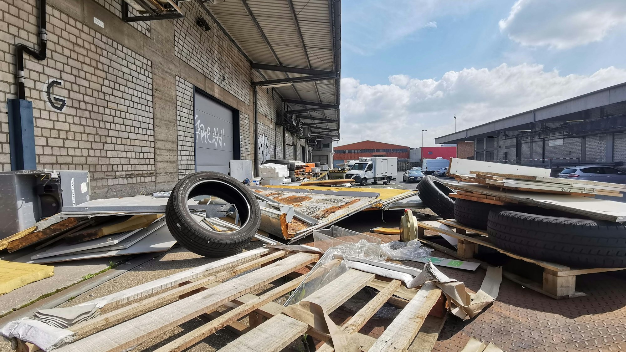 Alte und kaputte Paletten und abgefahrene Reifen liegen wahllos auf dem Gelände herum.