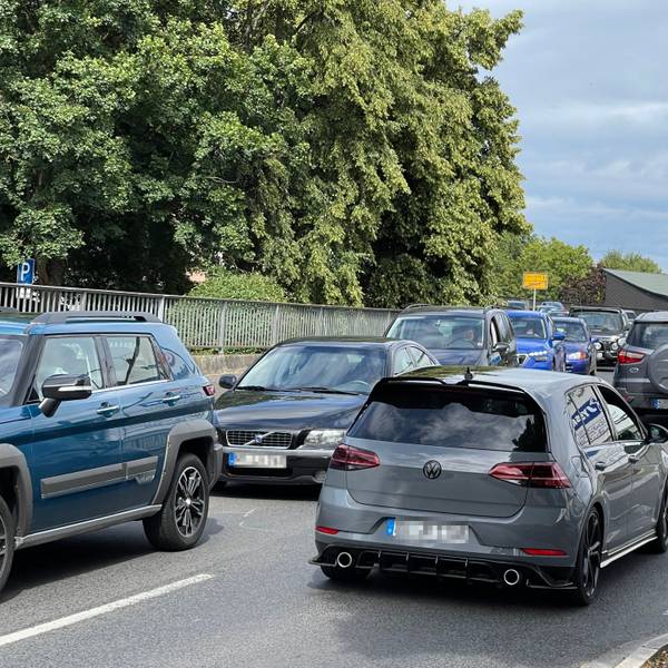 Auf einer Brücke ist ein langer Rückstau, auch die Gegenfahrbahn ist stark befahren.