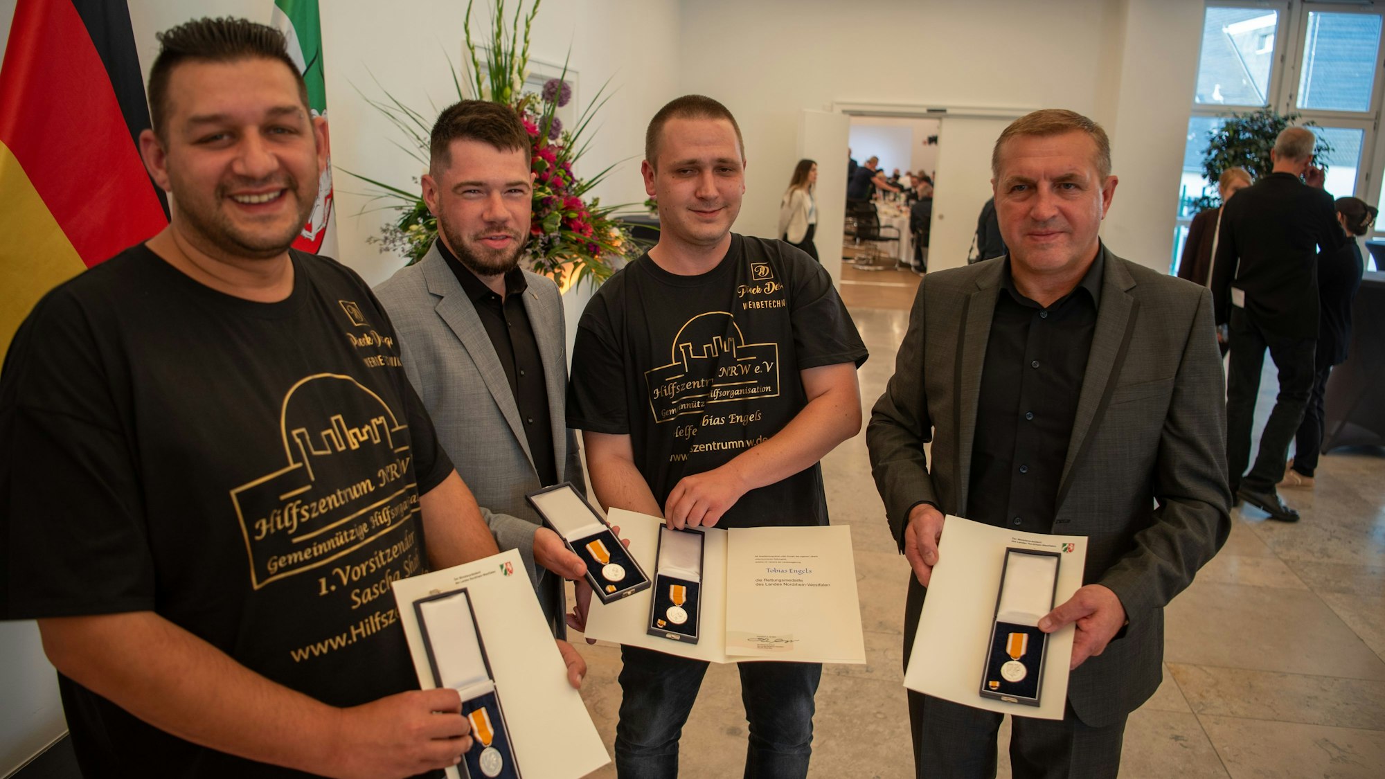 Sascha Sha, Niklas Roggendorf, Tobias Engels und Alexander Schmidt stehen nebeneinander und halten ihre Rettungsmedaillen in die Kamera.