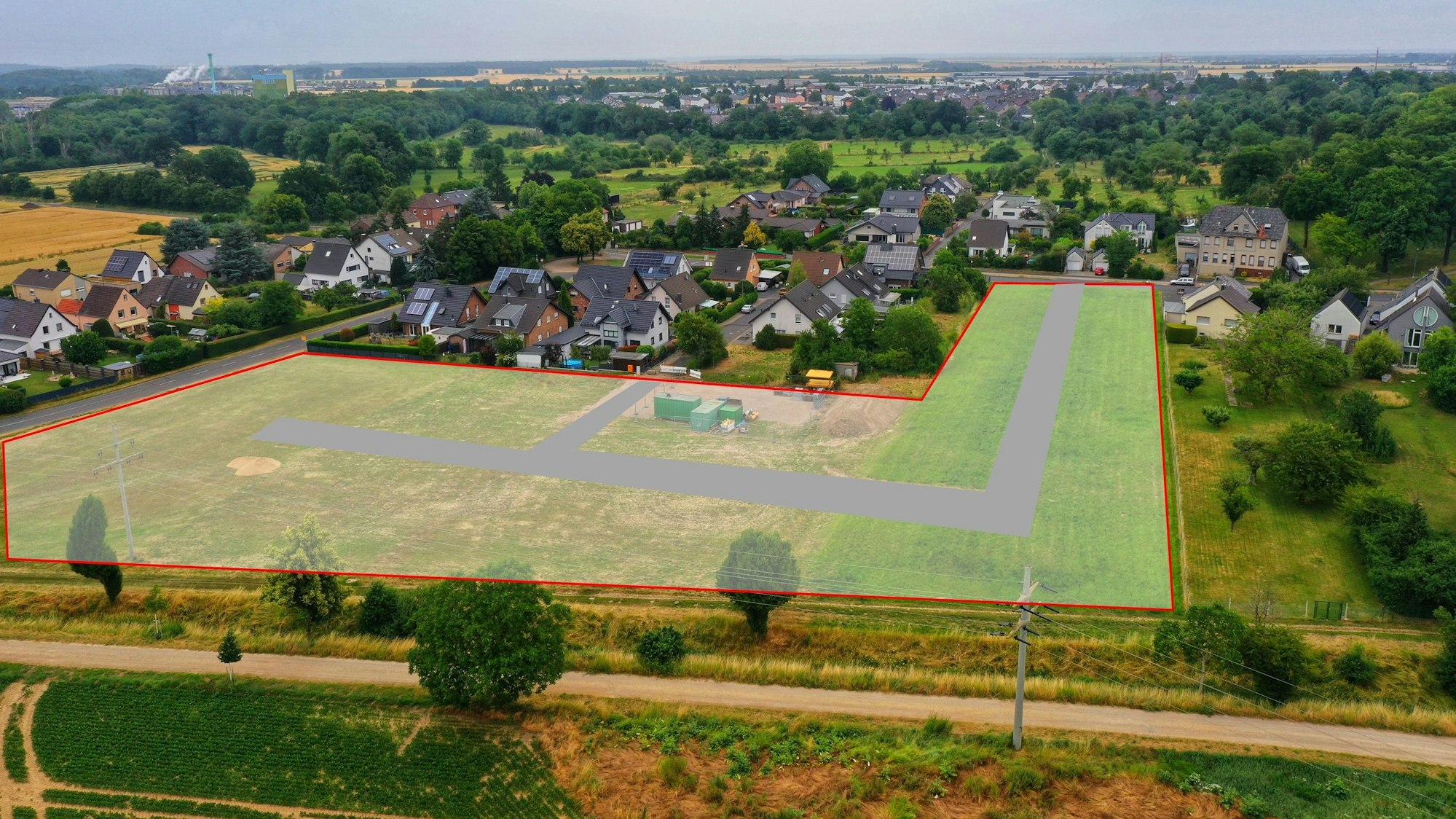 Ein Luftbild zeigt ein paar Häuser. Auf den Wiesen davor ist eingezeichnet, wo das neue Baugebiet entstehen soll.