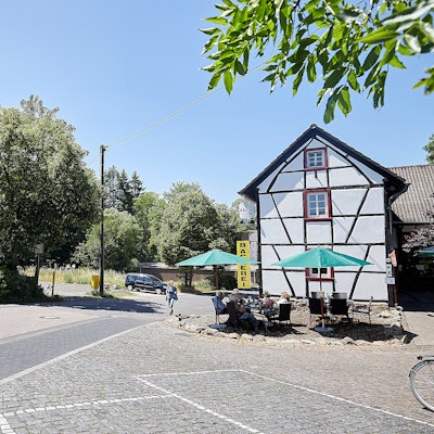 Auf dem Bild ist links das Café zur Römerquelle zu sehen, rechts der Parkplatz, auf dem ein Neubau entstehen soll.