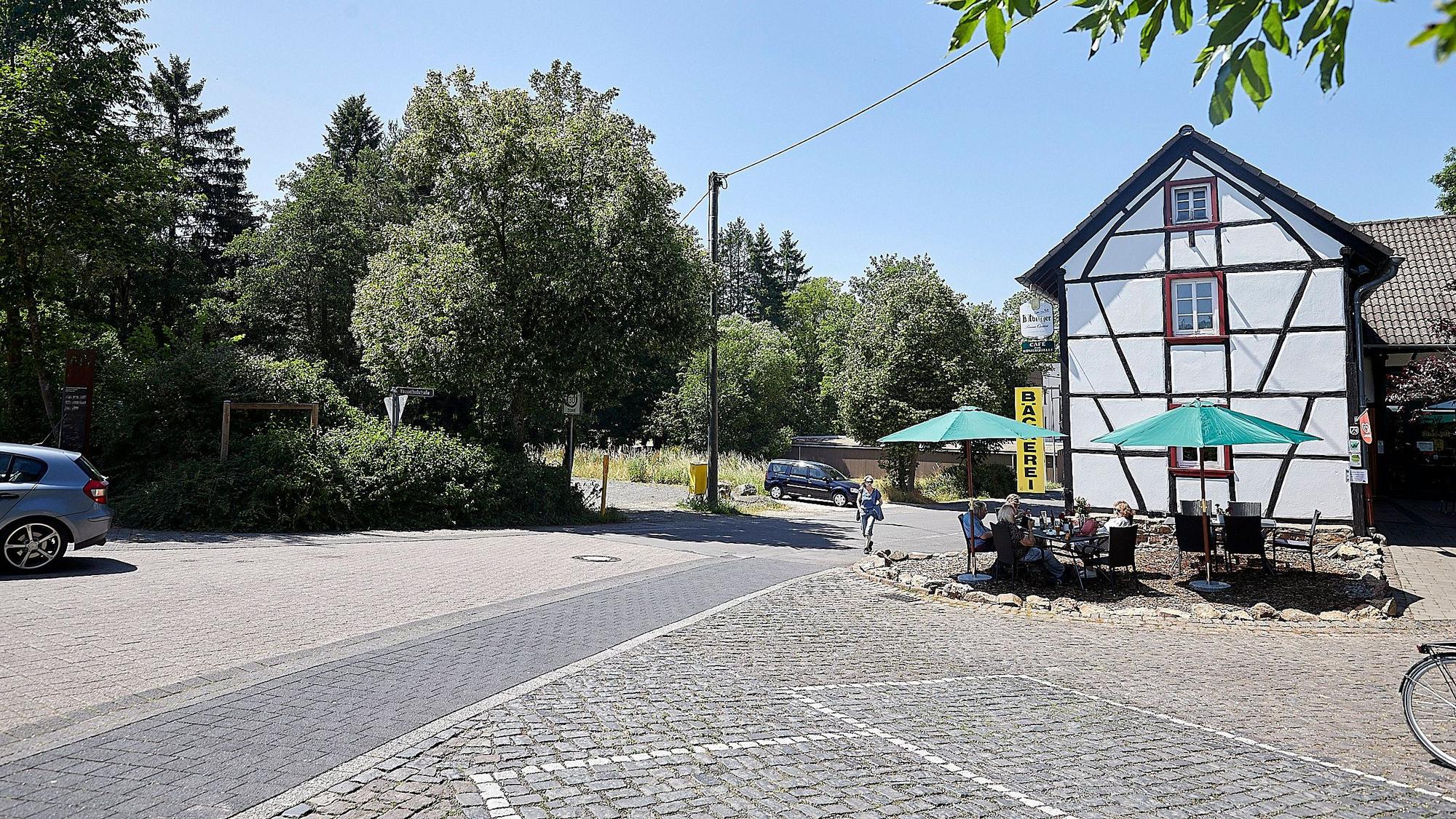 Auf dem Bild ist links das Café zur Römerquelle zu sehen, rechts der Parkplatz, auf dem ein Neubau entstehen soll.