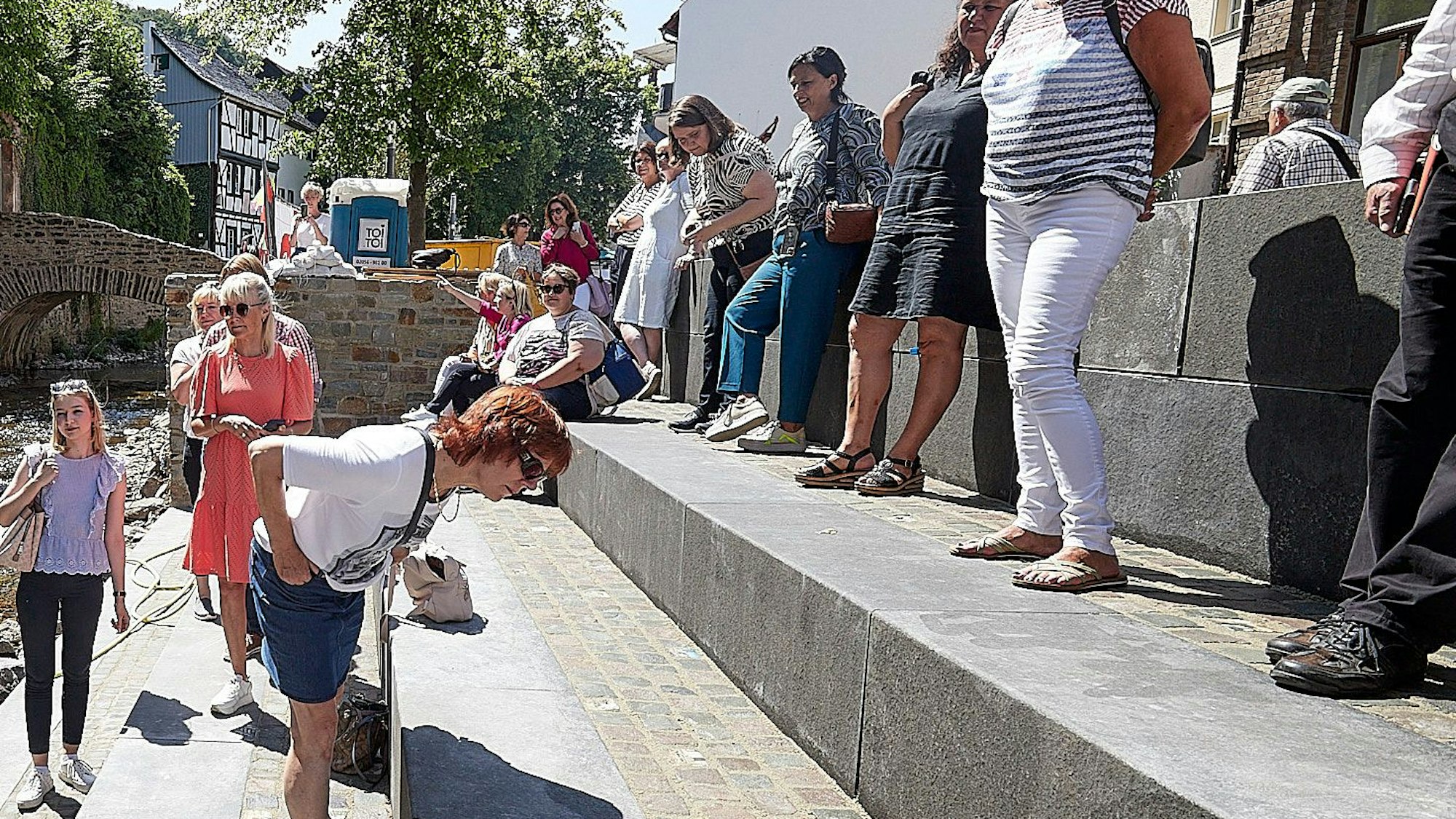 Einige Frauen schauen sich die neue Freitreppe zur Erft in Bad Münstereifel an.