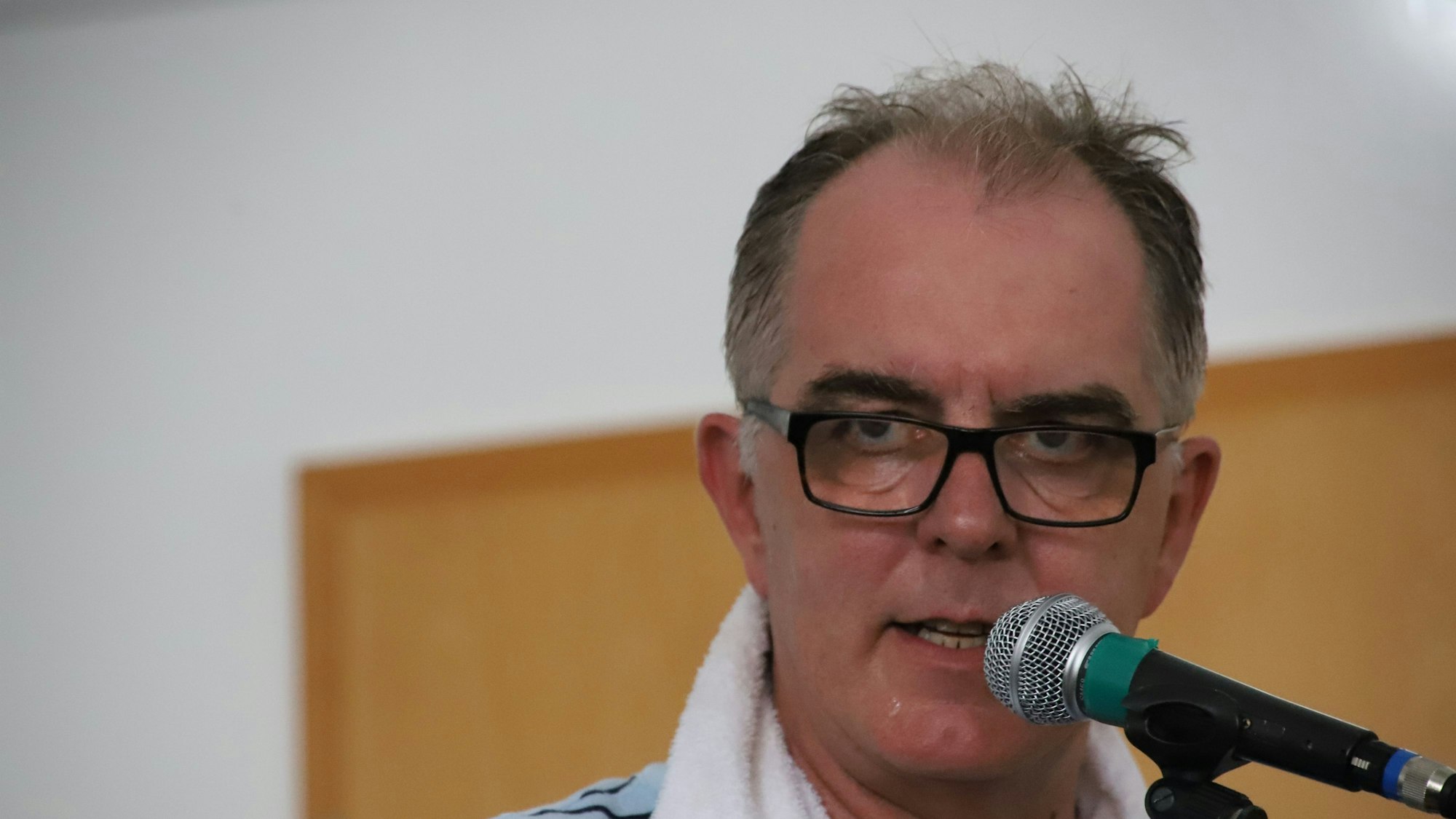Ein Mann steht am Mikrofon.