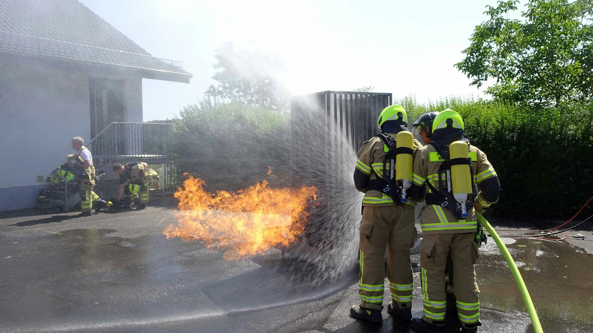 Gerätehaus Neukirchen, FF Rheinbach: Spezialtraining für sicheres Handeln bei Stromunfällen und Bränden in elektrischen Anlagen.
Auf dem Foto in voller Schutzausrüstung zu sehen sind die zwei Atemschutzträger Marvin Kramer (23 Jahre) und Christian Lücking (22 Jahre) vom Löschzug Rheinbach, die mit Unterstützung von Ausbilder Holger Schultze aus Dortmund einen - simulierten - Brand in einem Transformator löschen.