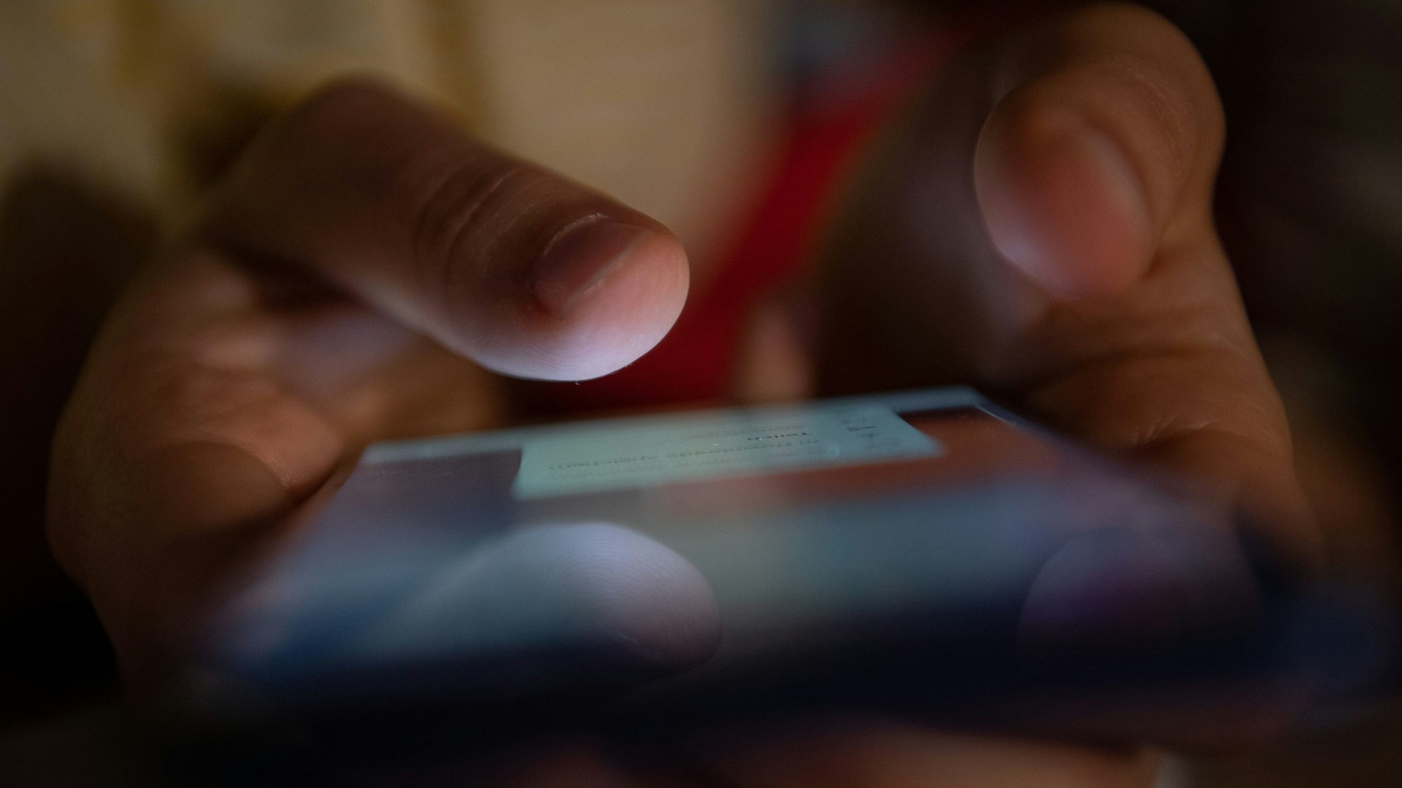 Ein Mann tippt etwas auf ein Smartphone