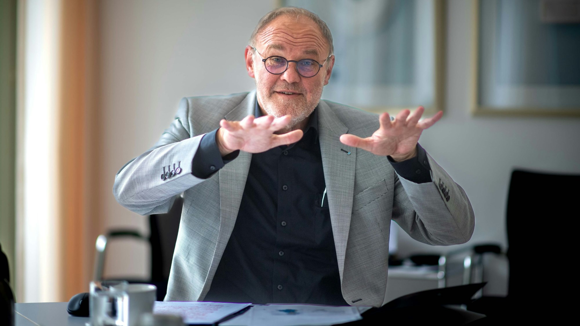 Erftverband-Vorstand Dr. Bernd Bucher sitzt gestikulierend hinter seinem Schreibtisch.