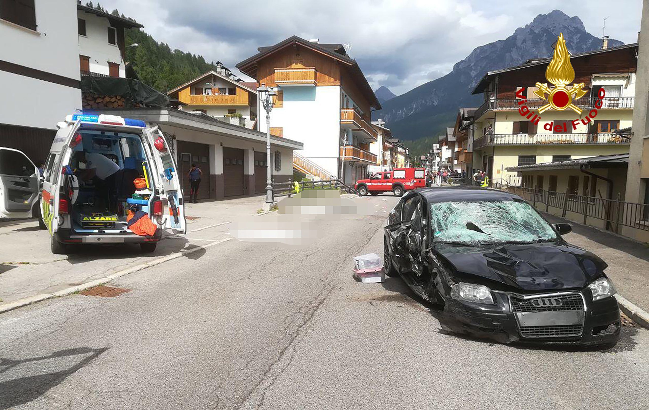 Ein Krankenwagen und das Auto der Deutschen stehen nach dem Unfall neben den Opfern (gepixelt), die auf einer Straße liegen.