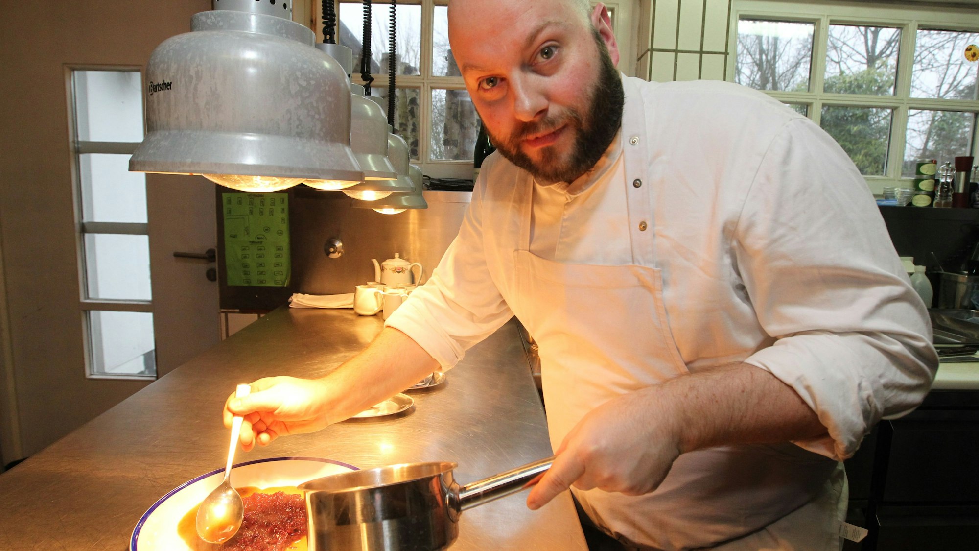 Ein Koch richtet einen Teller an.