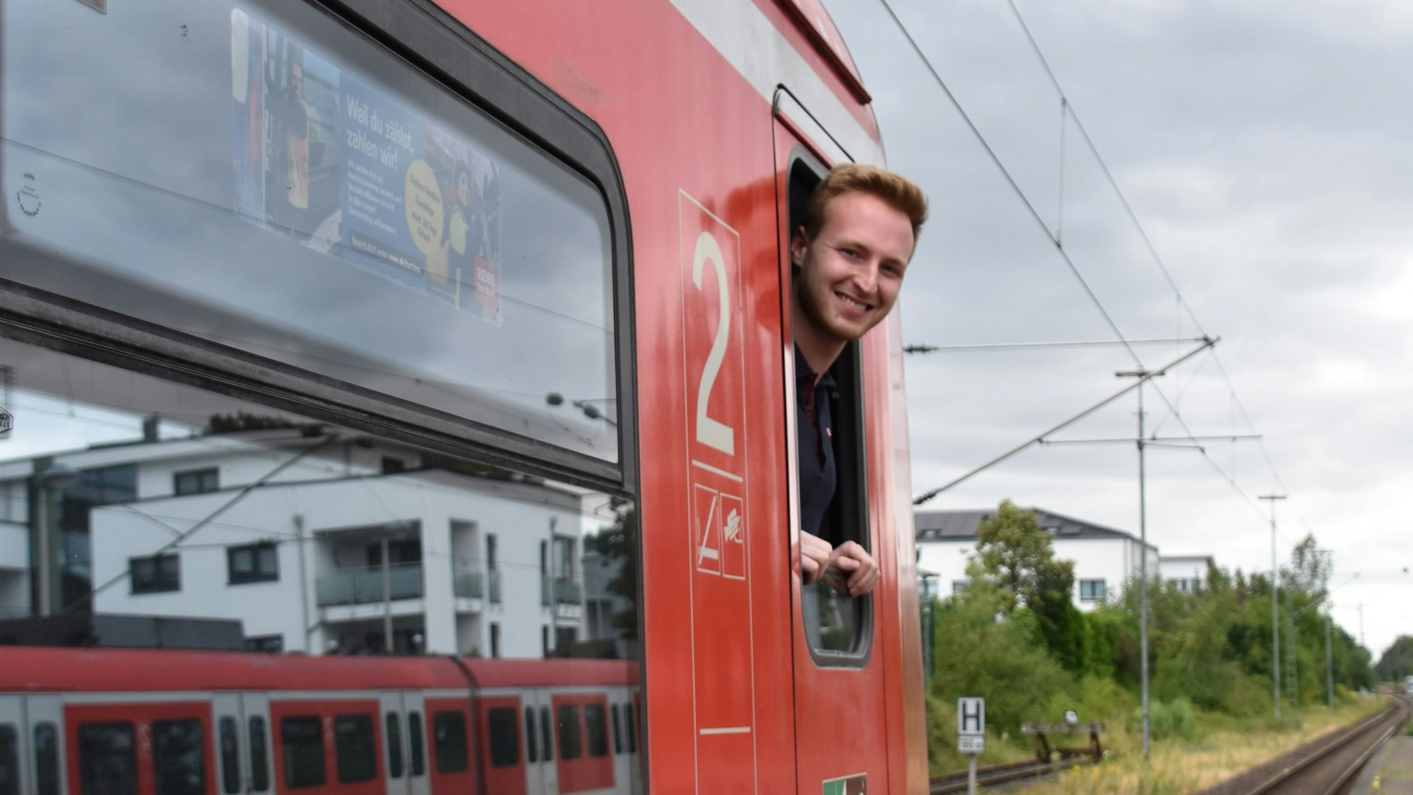Ein Mann blickt aus dem Fenster eines Zuges.