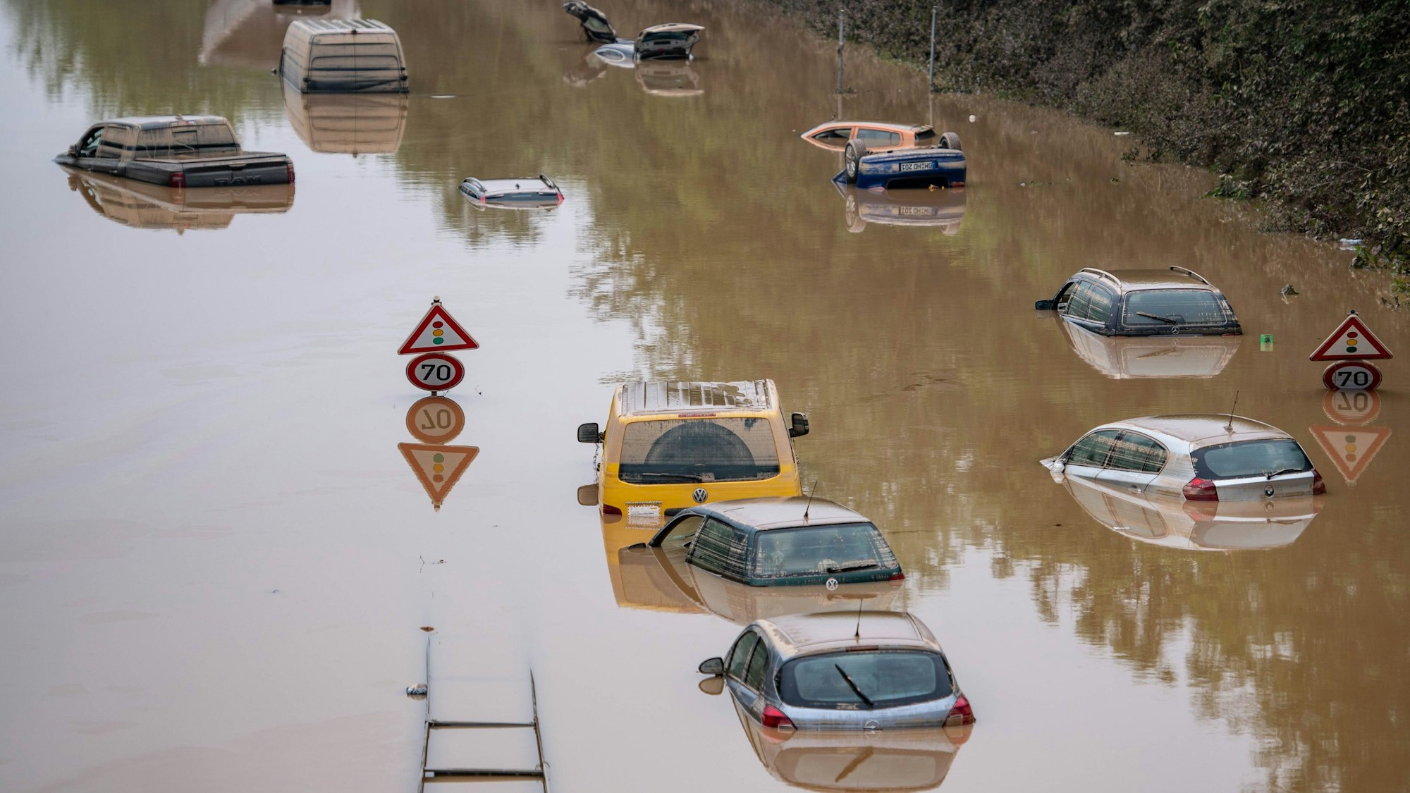 Autos stehen auf der überfluteten Bundesstraße 265 bei Erftstadt im Wasser.